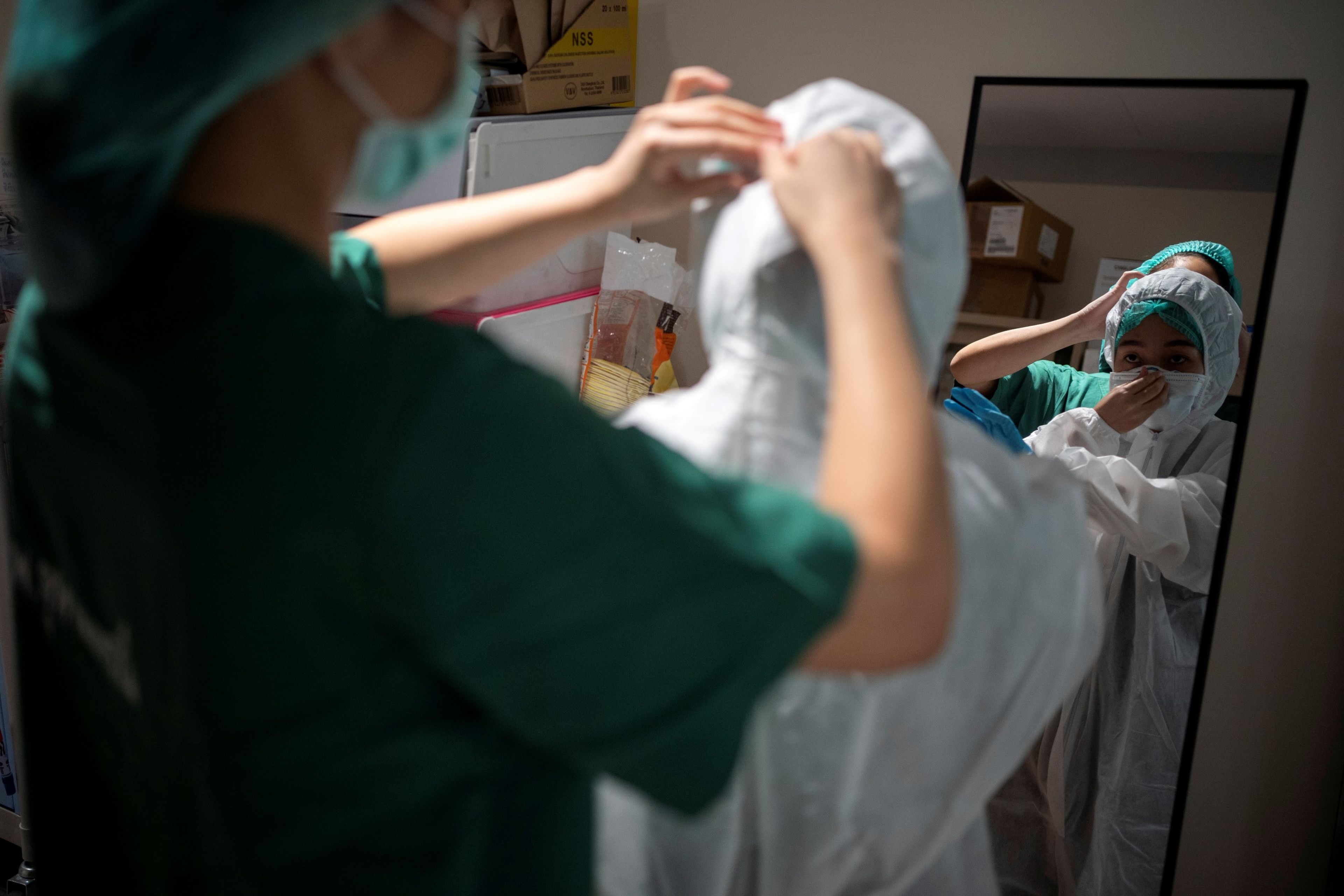 Una enfermera se coloca un traje protector en medio de la pandemia del coronavirus