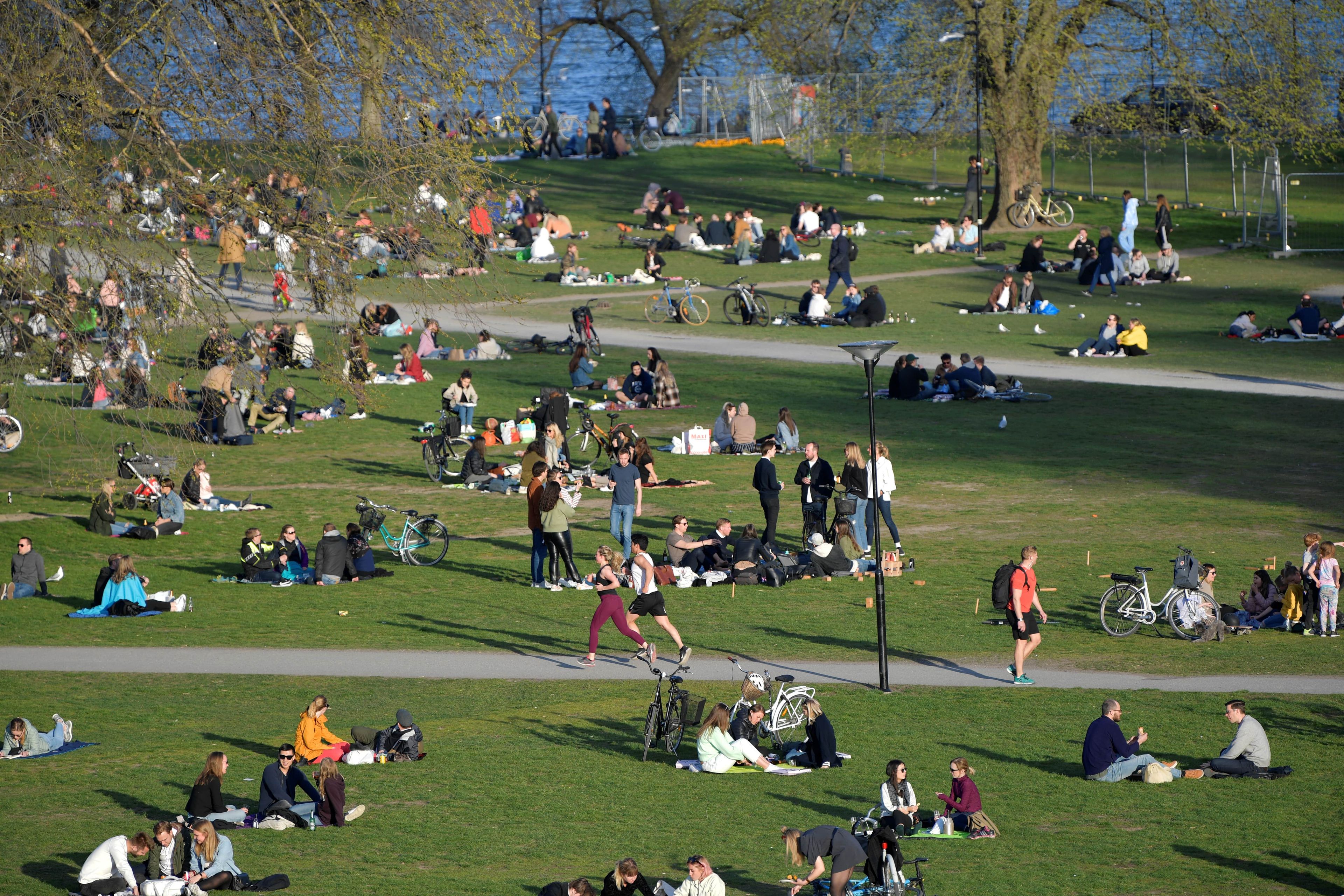 Personas disfrutando de la primavera en un parque de Estocolmo (Suecia) donde las medidas han sido muy laxas, buscando así la inmunidad de rebaño