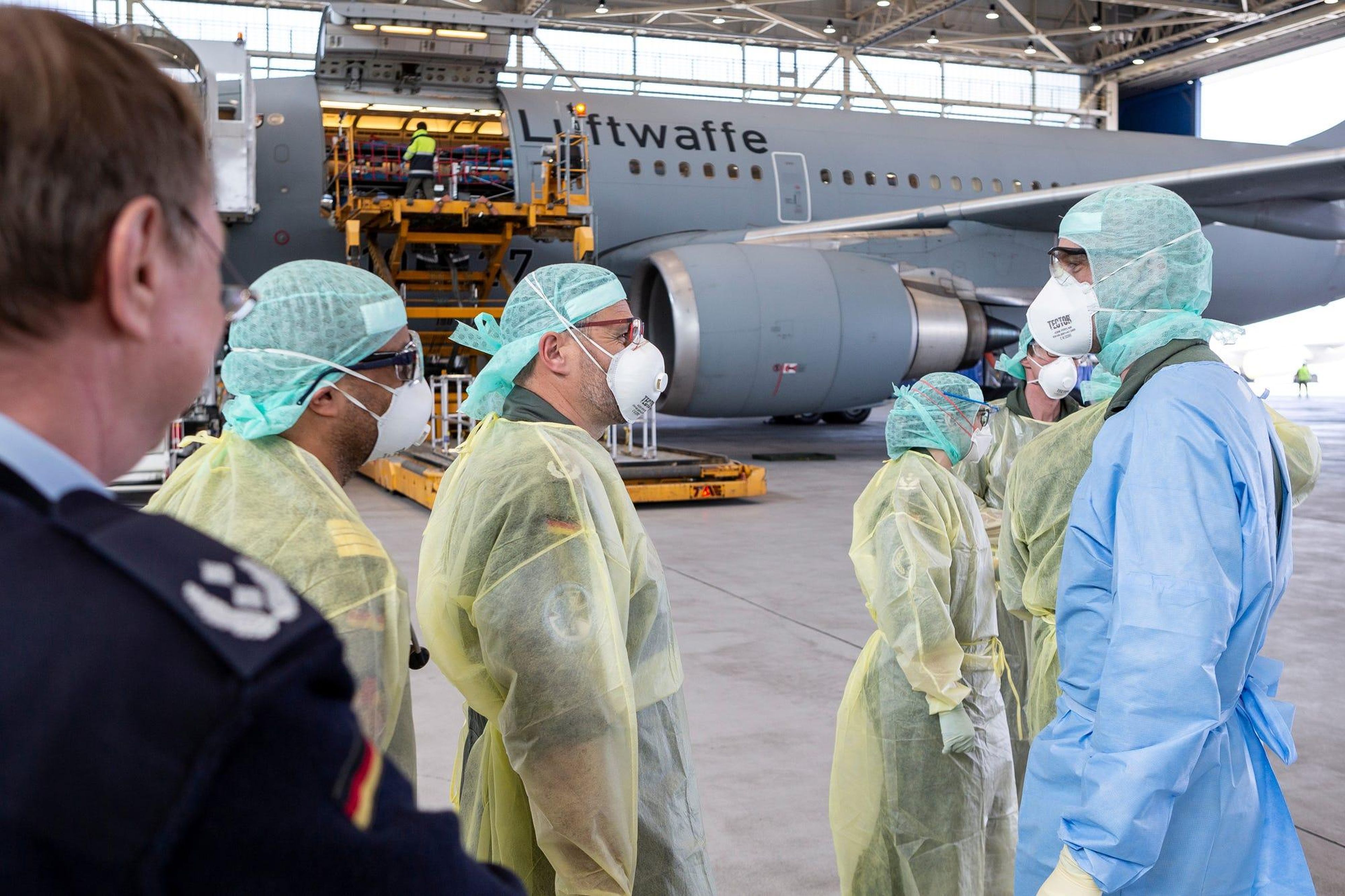 Personal médico con equipos de protección individual que abandonan el Airbus A310 "Medevac" junto con pacientes con coronavirus después de aterrizar en Colonia, Alemania, el 28 de marzo.