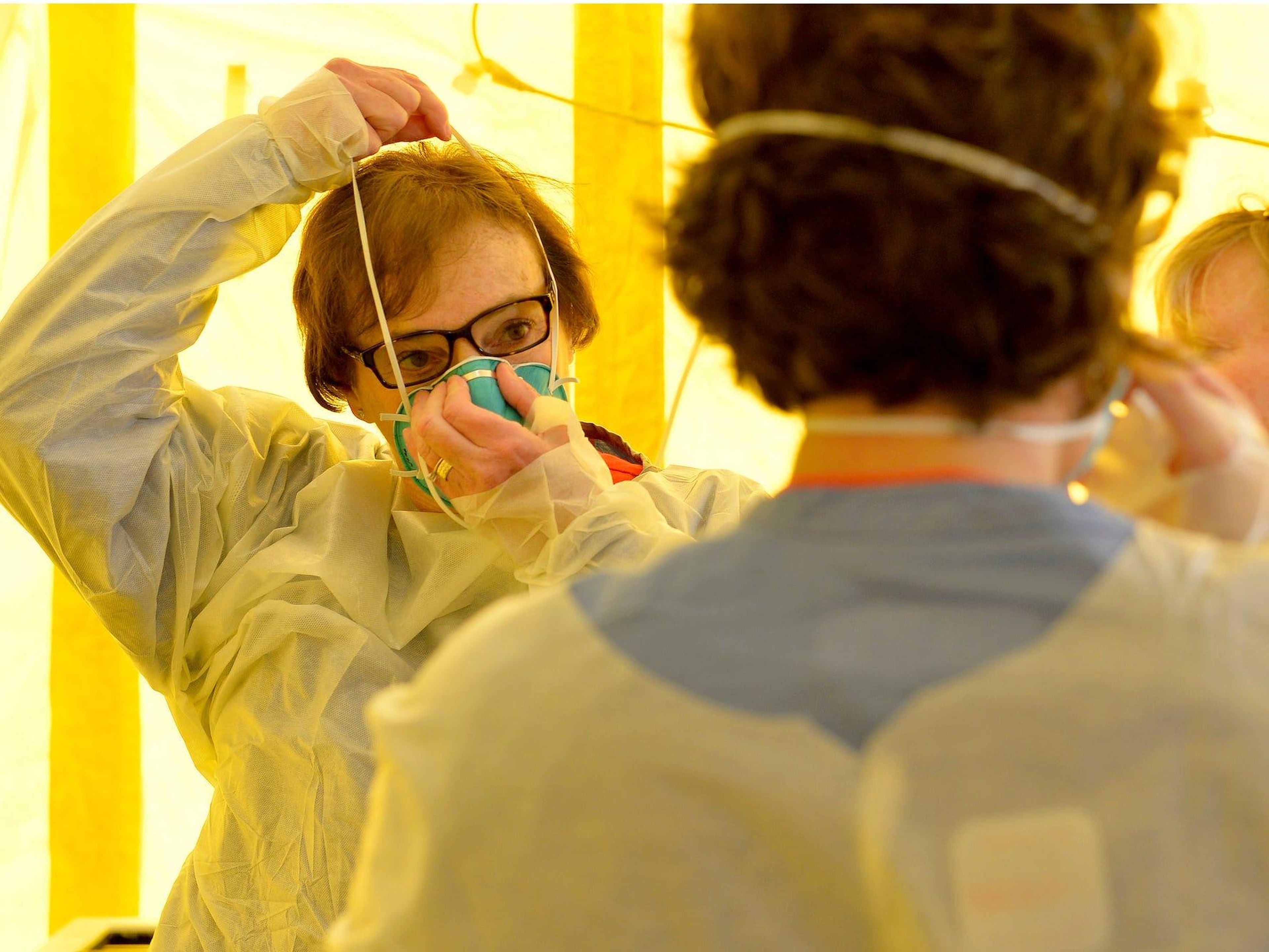Sanitarios poniéndose equipos de protección antes de examinar a pacientes posibles casos de coronavirus en el Hospital Newton-Wellesley de Newton, Massachusetts, EEUU.