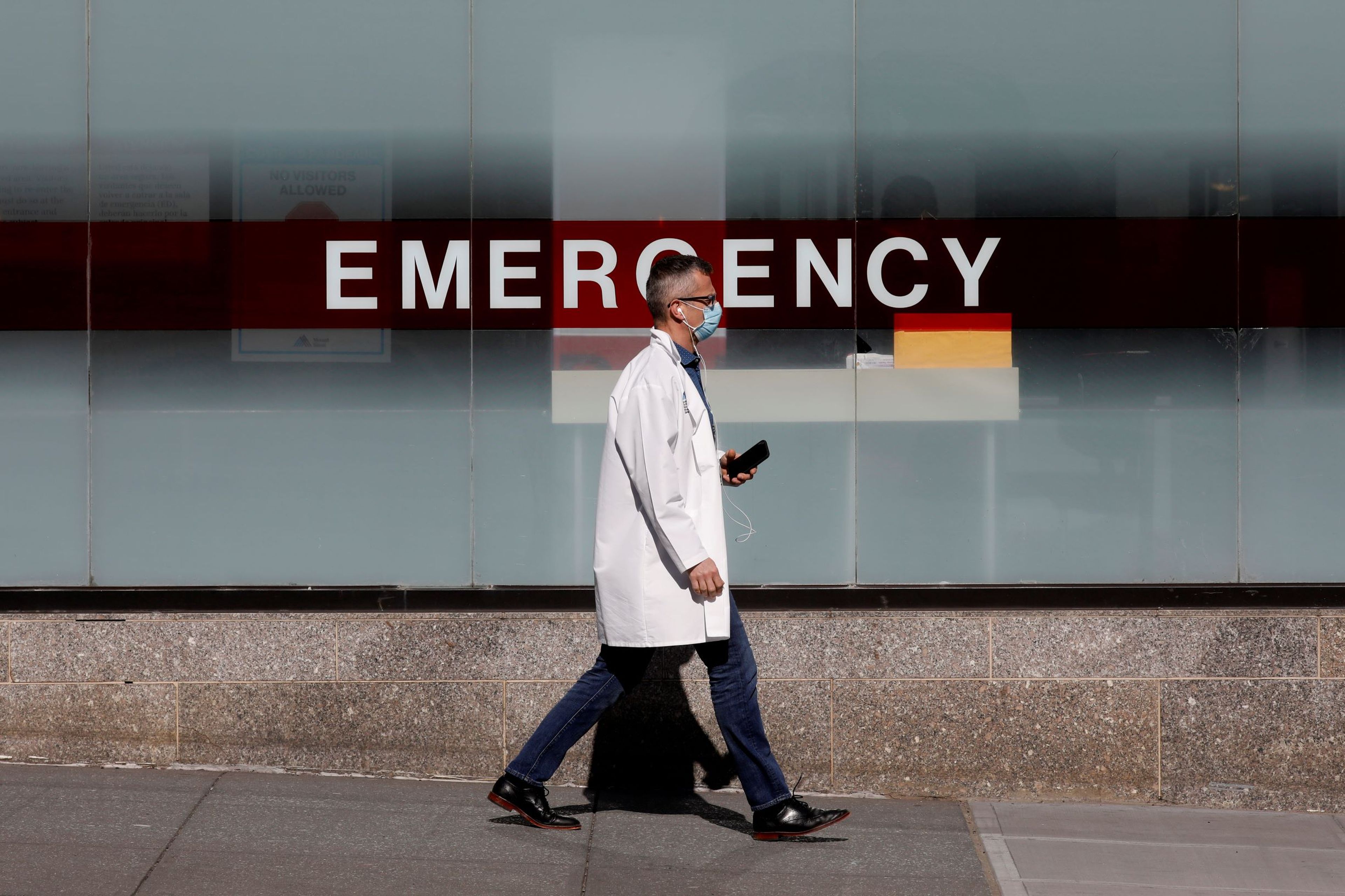 Un medico usa una mascara protectora mientras camina afuera del Hospital Mount Sinai durante el brote de la enfermedad por coronavirus en Nueva York