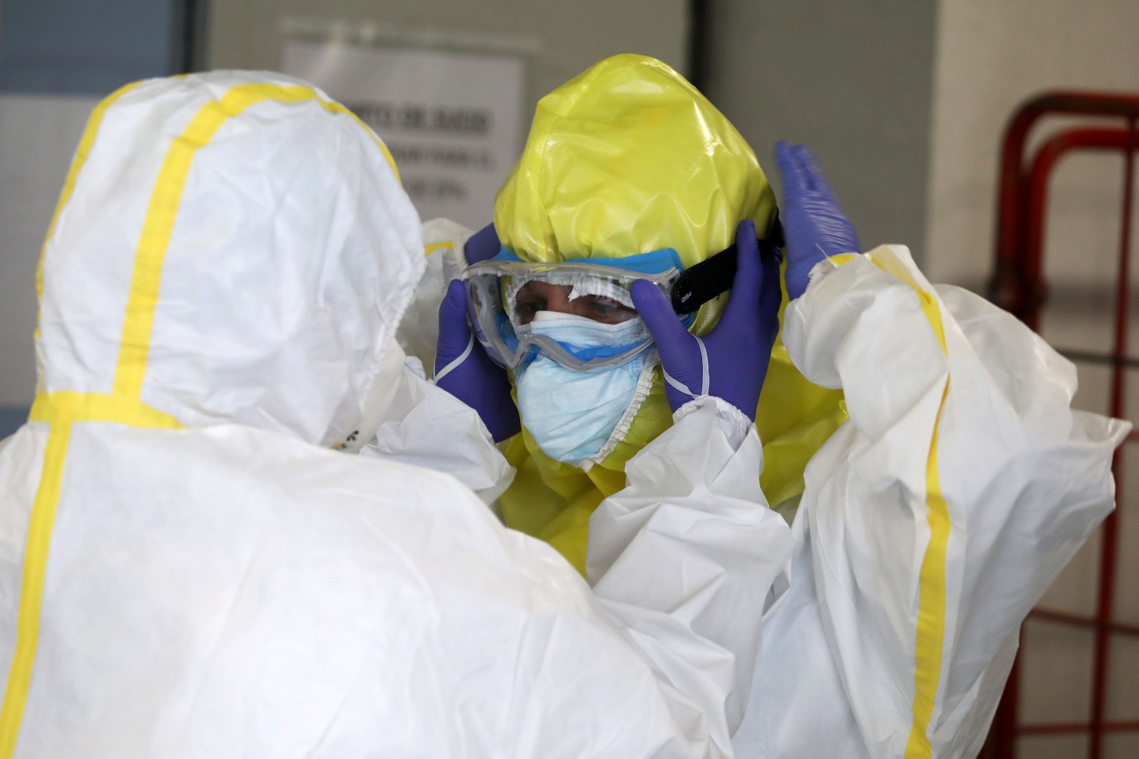 Miembros del SUMMA se equipan con trajes protectores antes de visitar a un paciente con coronavirus