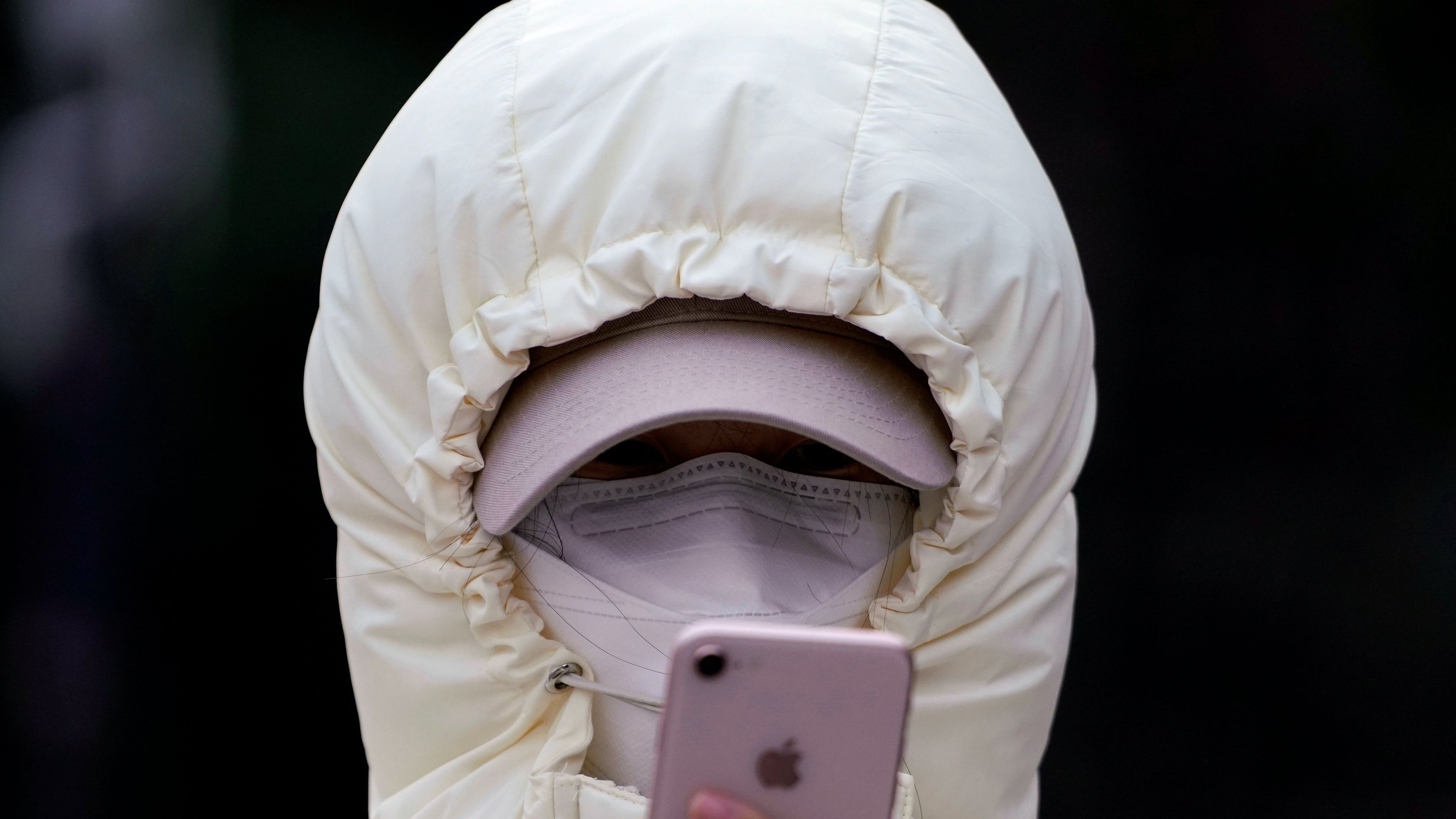 Una mujer con mascarilla mira su móvil en plena crisis de coronavirus.