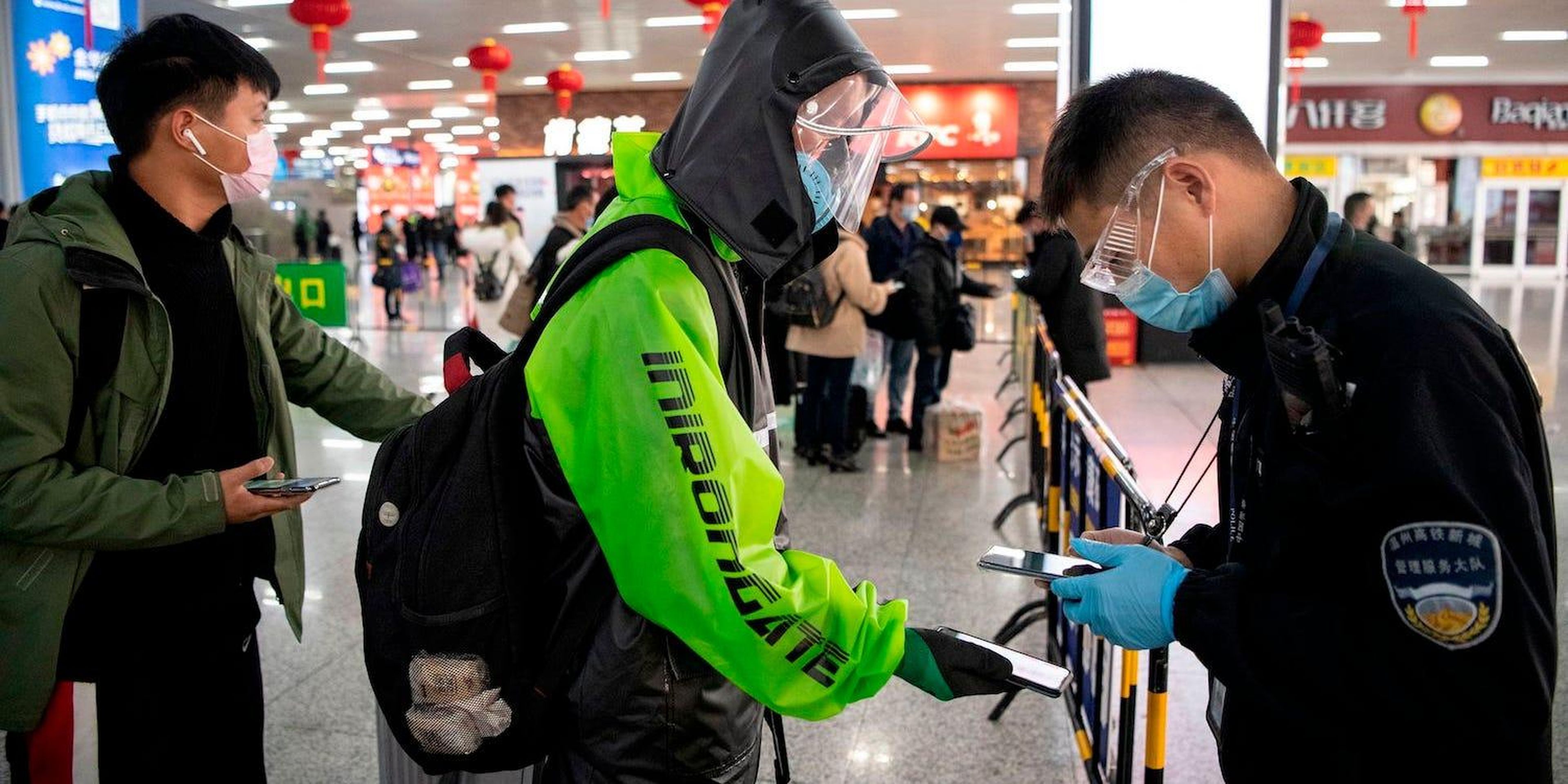 Un pasajero muestra un código QR verde en su teléfono que indica su estado de salud a la seguridad al llegar a la estación de tren de Wenzhou el 28 de febrero de 2020.