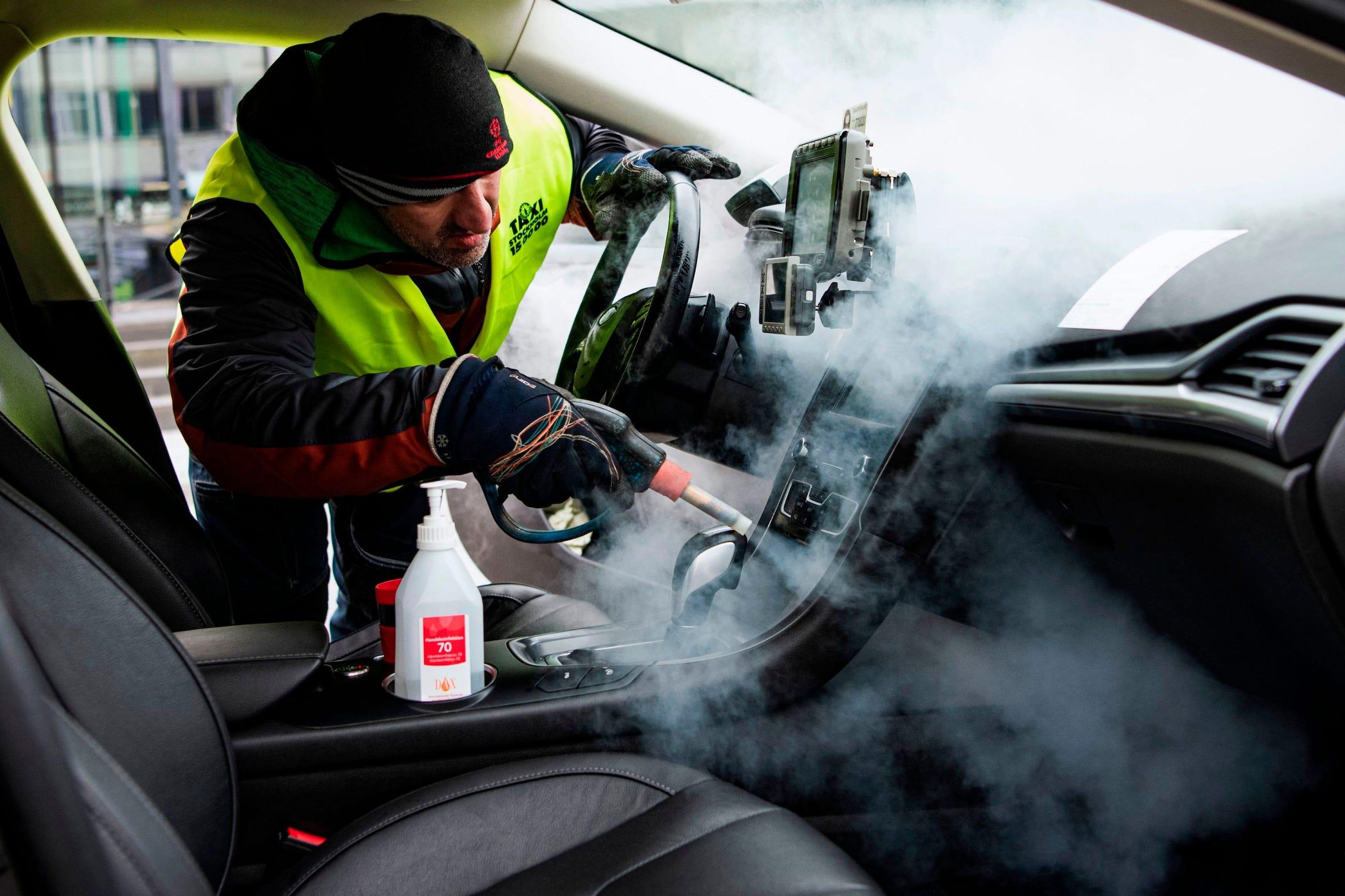 Una persona limpia y desinfecta un taxi en Estocolmo, Suecia, el 24 de marzo de 2020, para evitar la propagación del coronavirus.