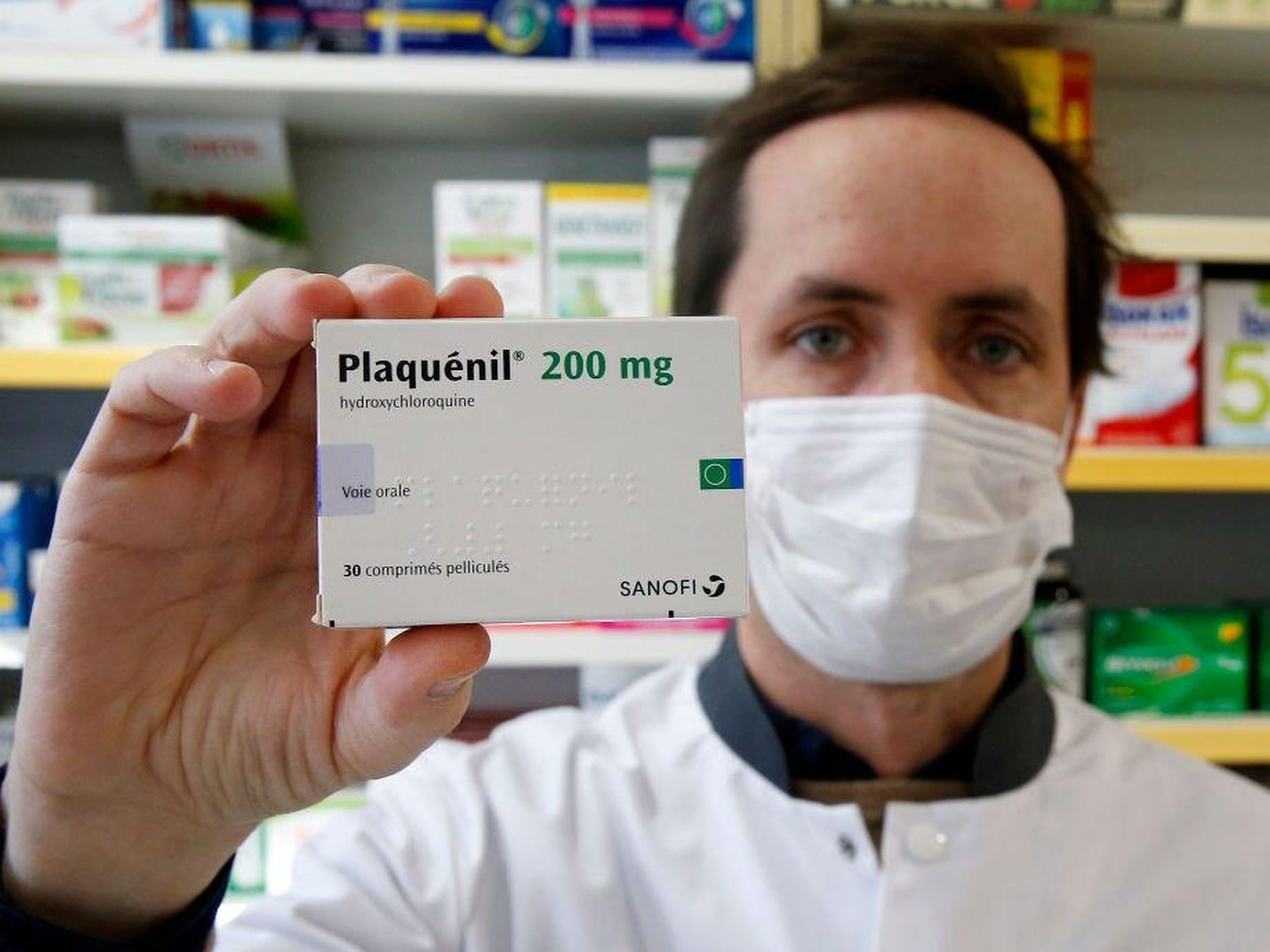 A pharmacy worker with a box of hydroxychloroquine on March 25.