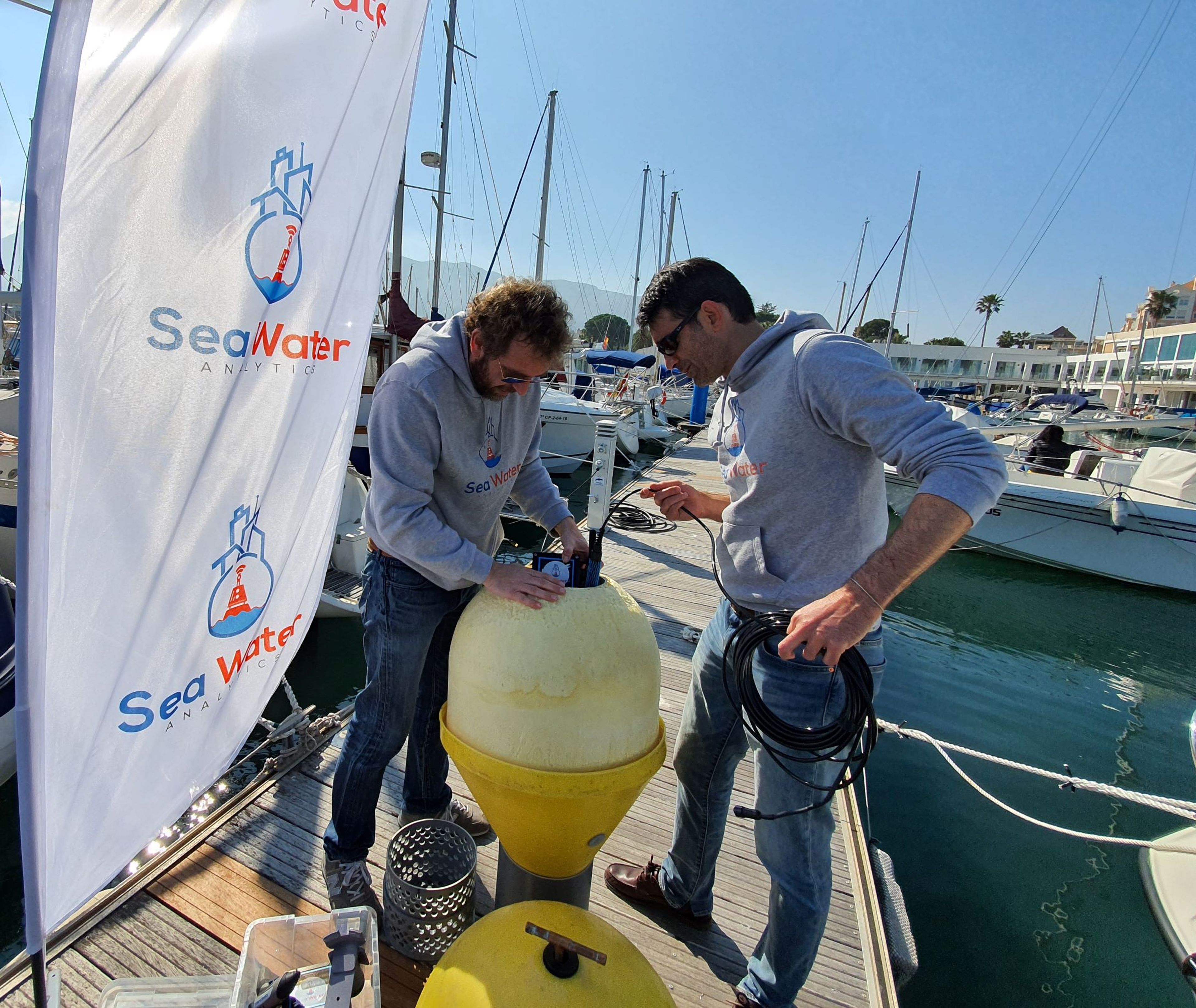 Javier Colmenarejo y Javier Moya, fundadores de Sea Water Analytics, con una de las boyas inteligentes.