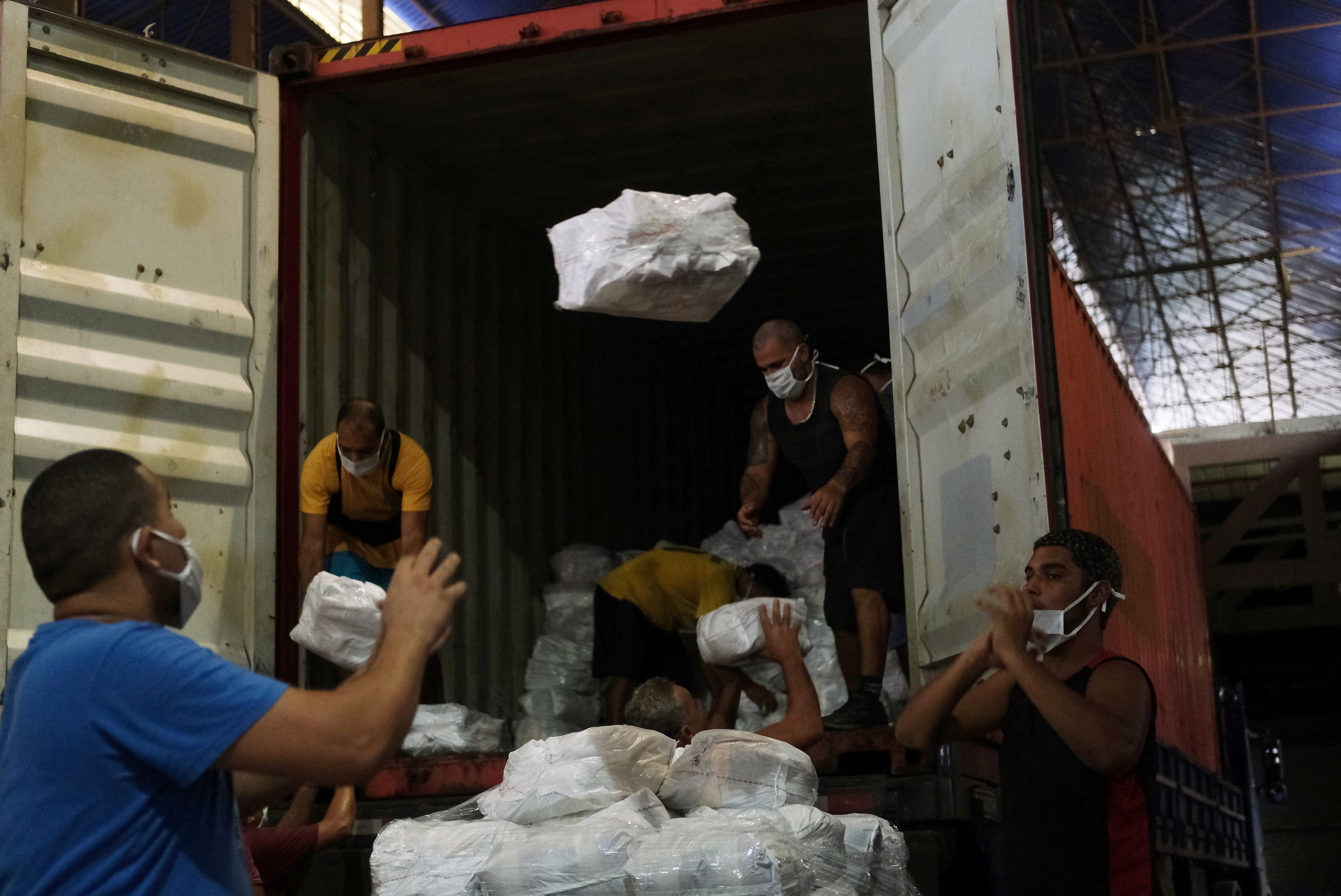 Trabajadores descargan camiones con donaciones en Río de Janeiro, el 17 de abril de 2020.