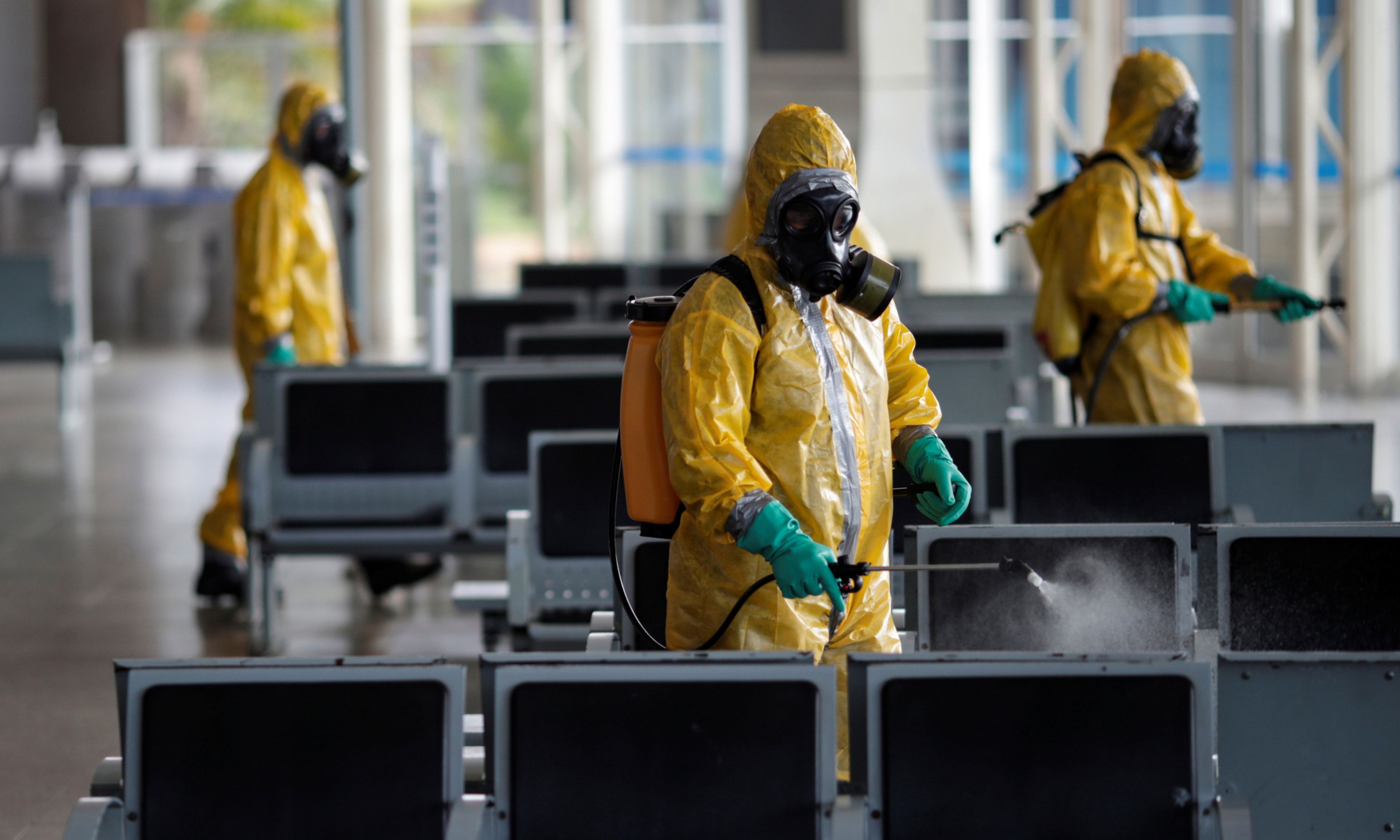 Trabajadores sanitarios desinfectan el aeropuerto de Brasilia