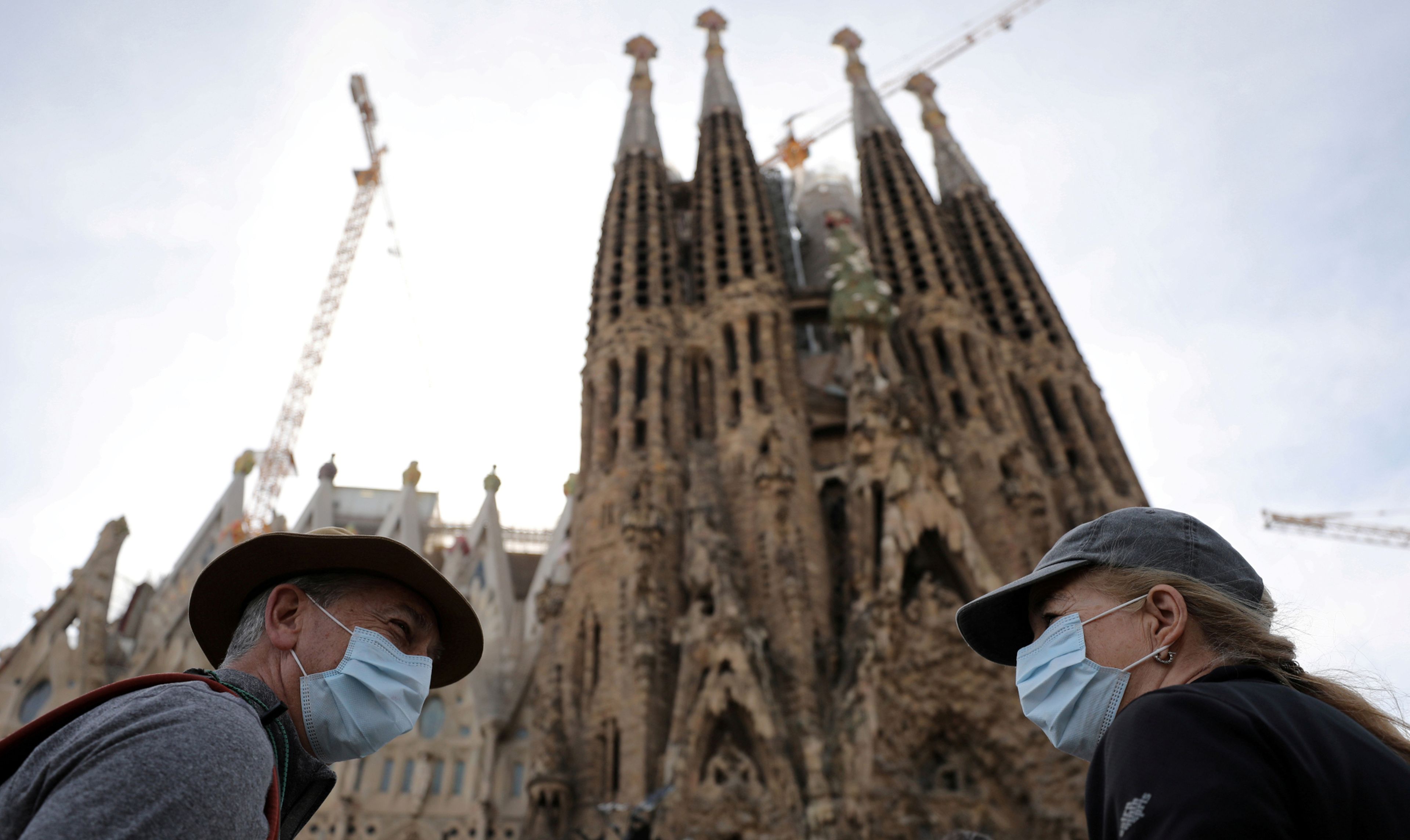 Turistas con mascarilla ante la Sagrada Familia de Barcelona