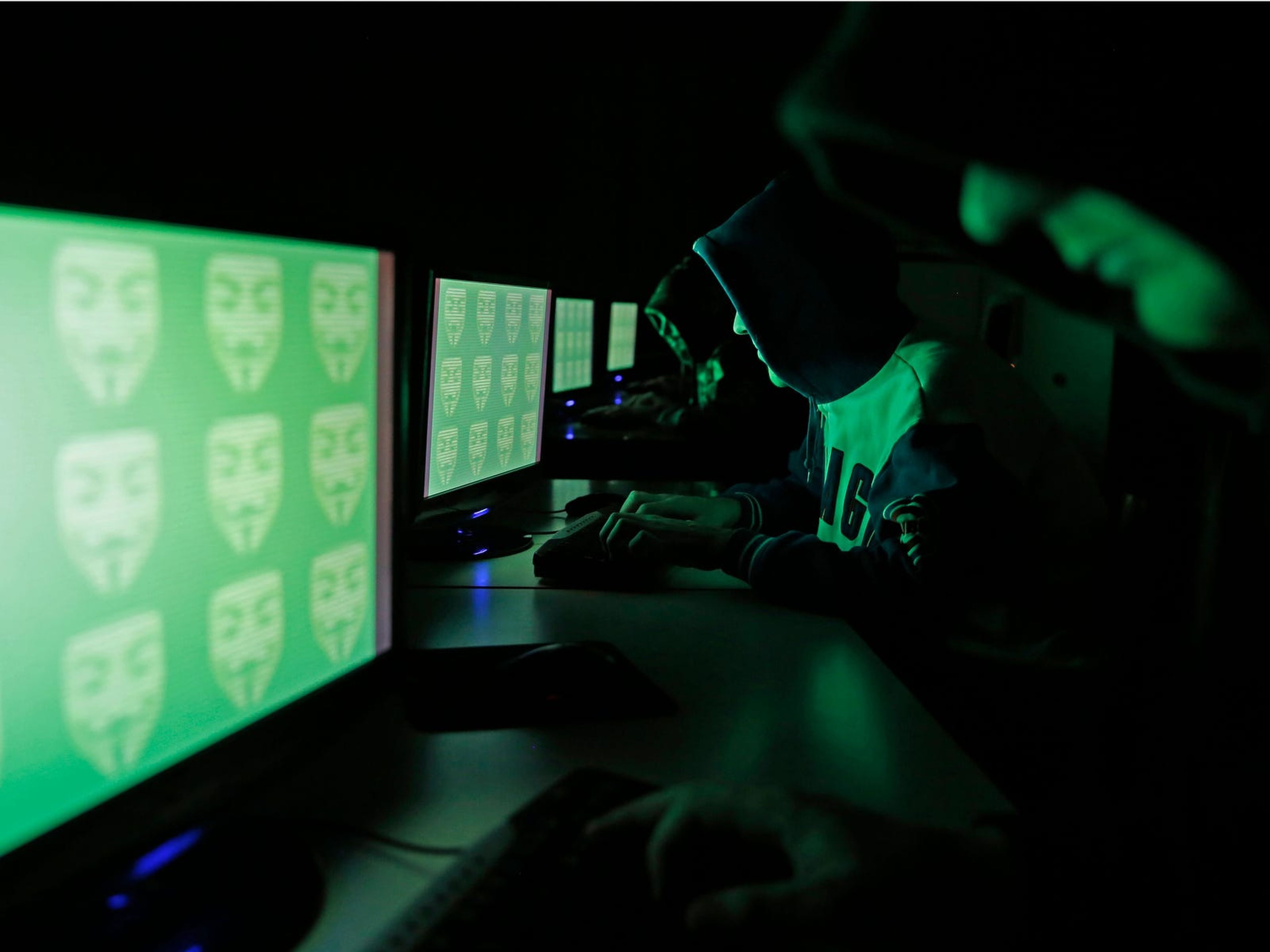 Gente frente a una pantalla que muestra la palabra 'cyber' en código binario, en esta imagen tomada en Zenica el 27 de diciembre de 2014.