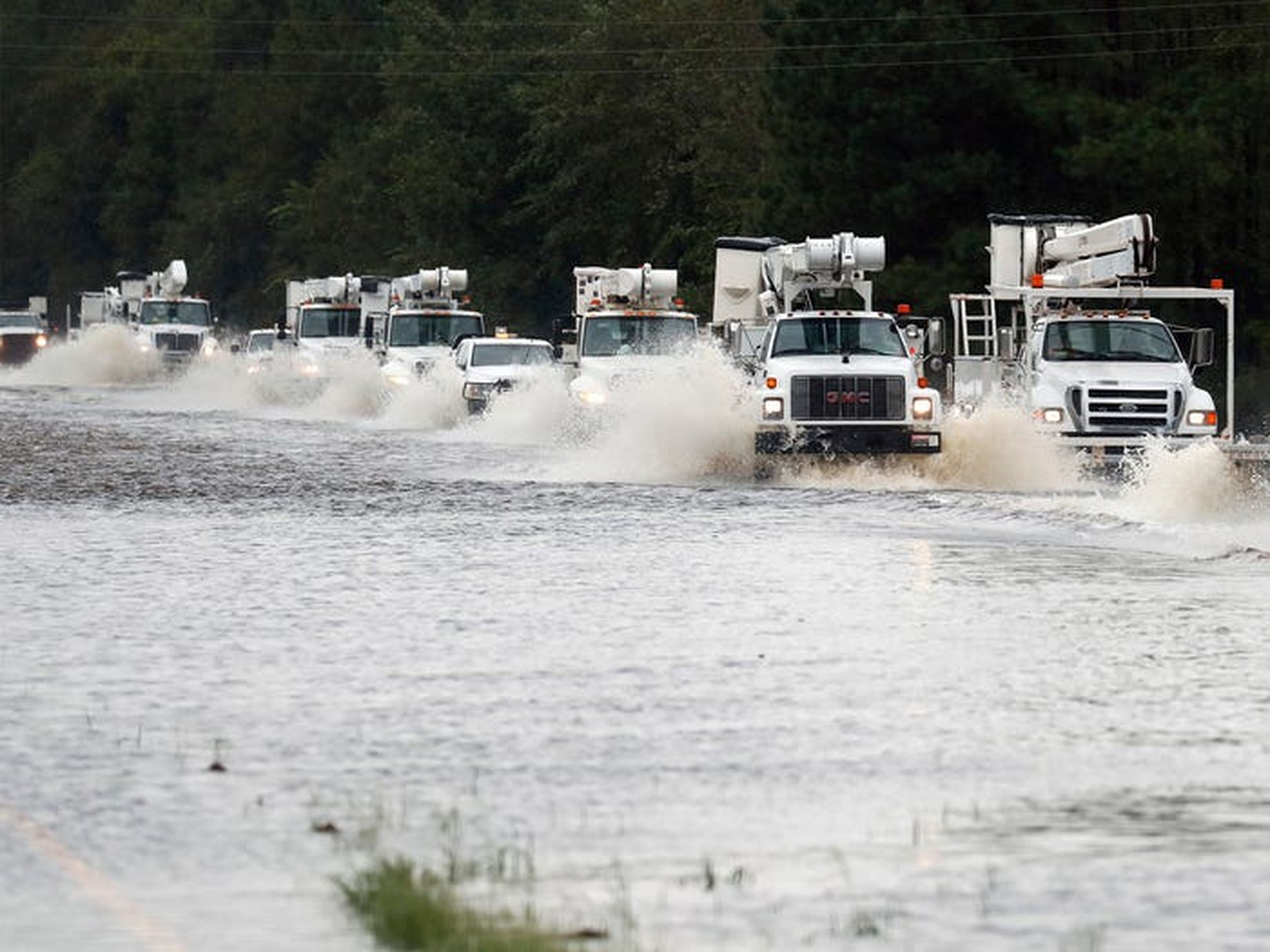 Un convoy de camiones utilitarios que se dirigen al este para ayudar con los daños causados por la tormenta tropical Florence se abre paso a través de un tramo de autopista.