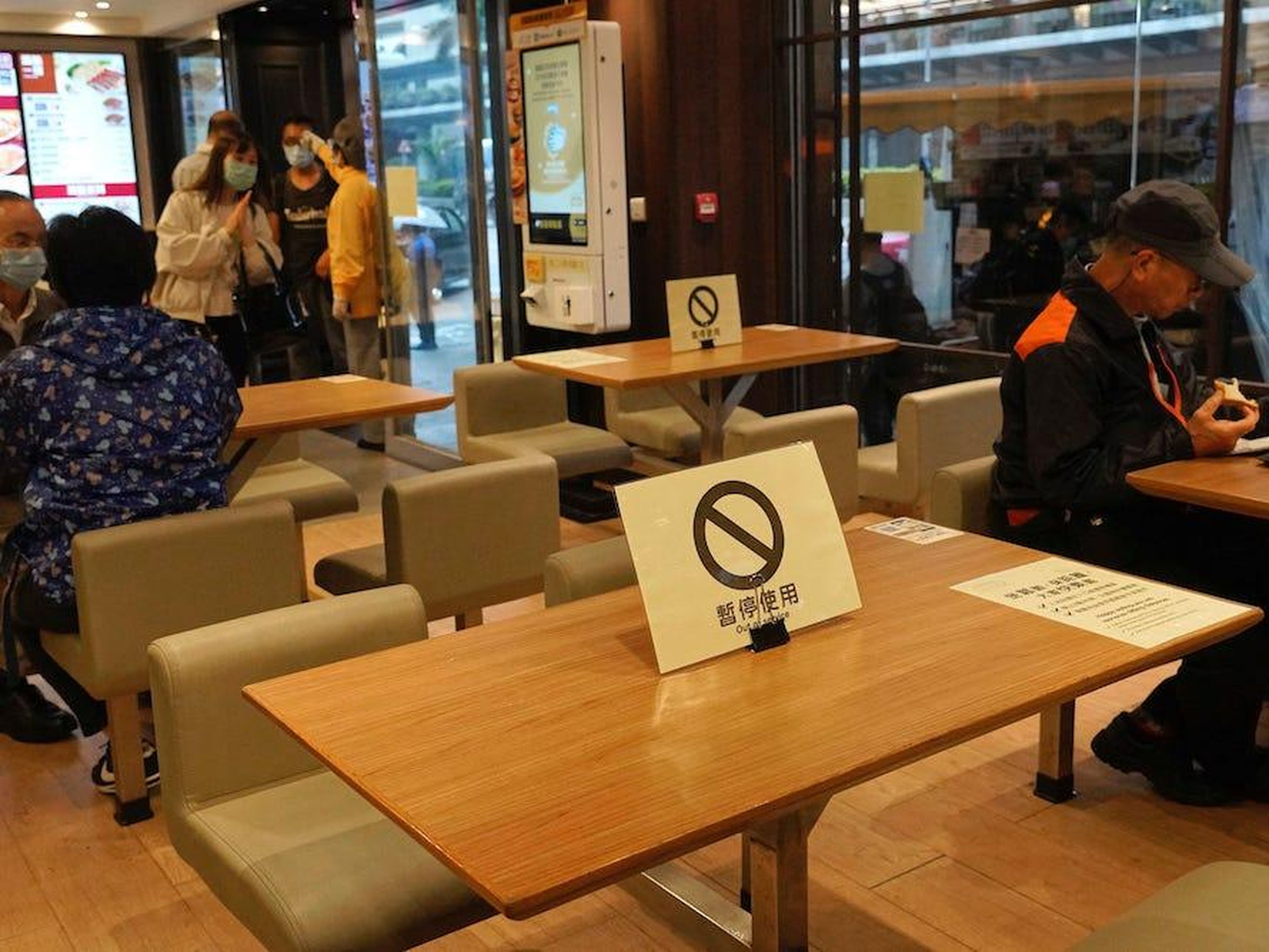 Señales de distanciamiento social en las mesas de un restaurante en Hong Kong.
