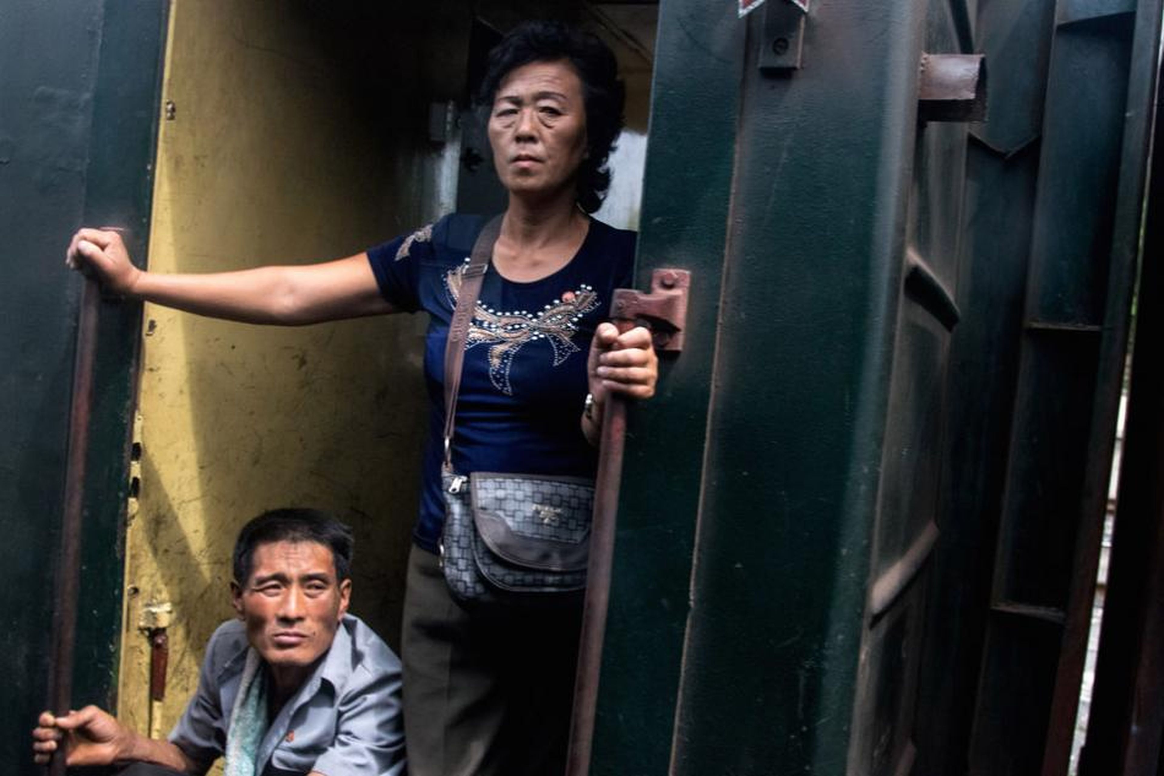 Gente relajándose en la puerta de un vagón de tren (Corea del Norte, agosto de 2015).