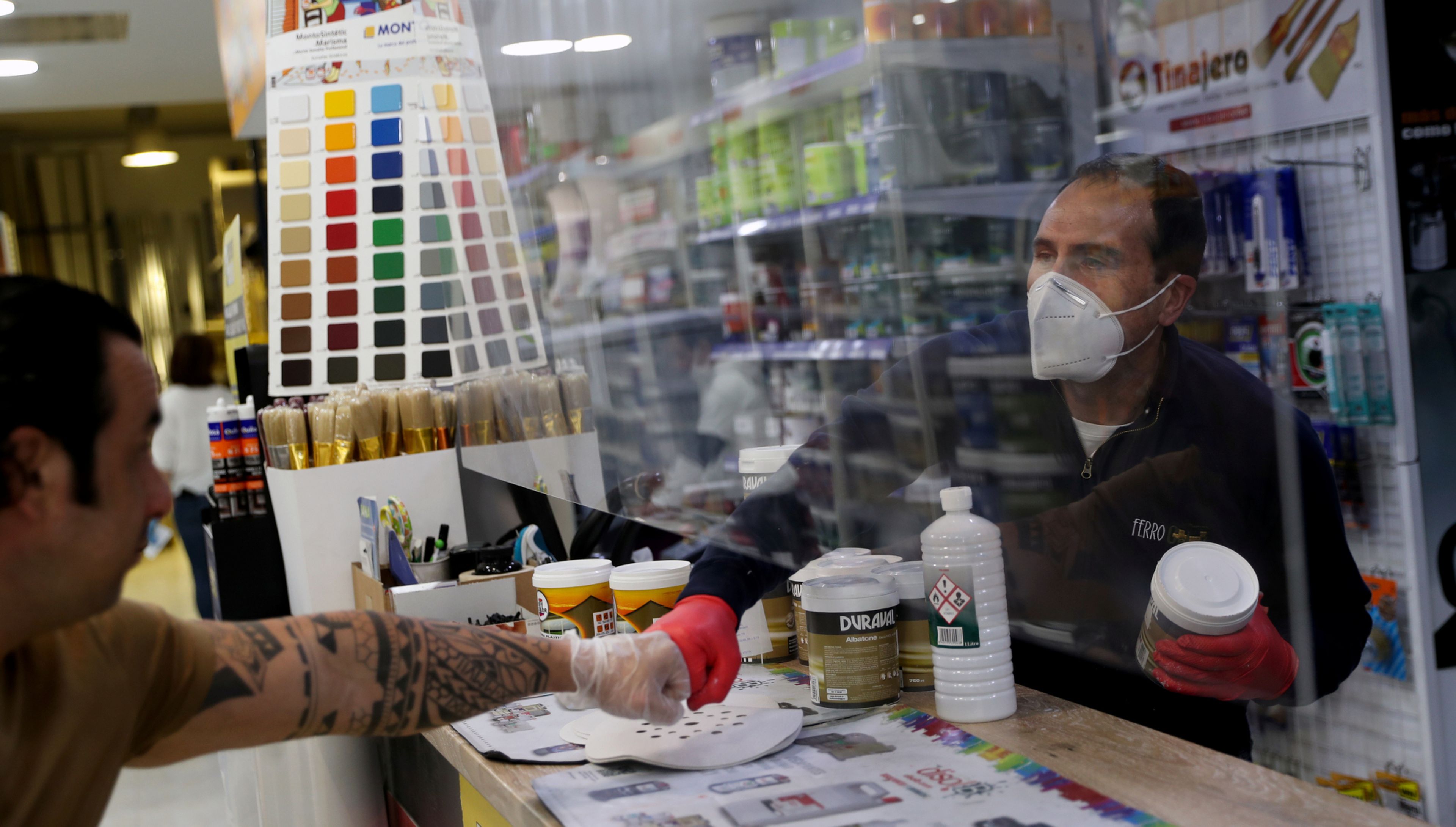 Un cliente saluda al dependiente de una tienda de pintura en Madrid