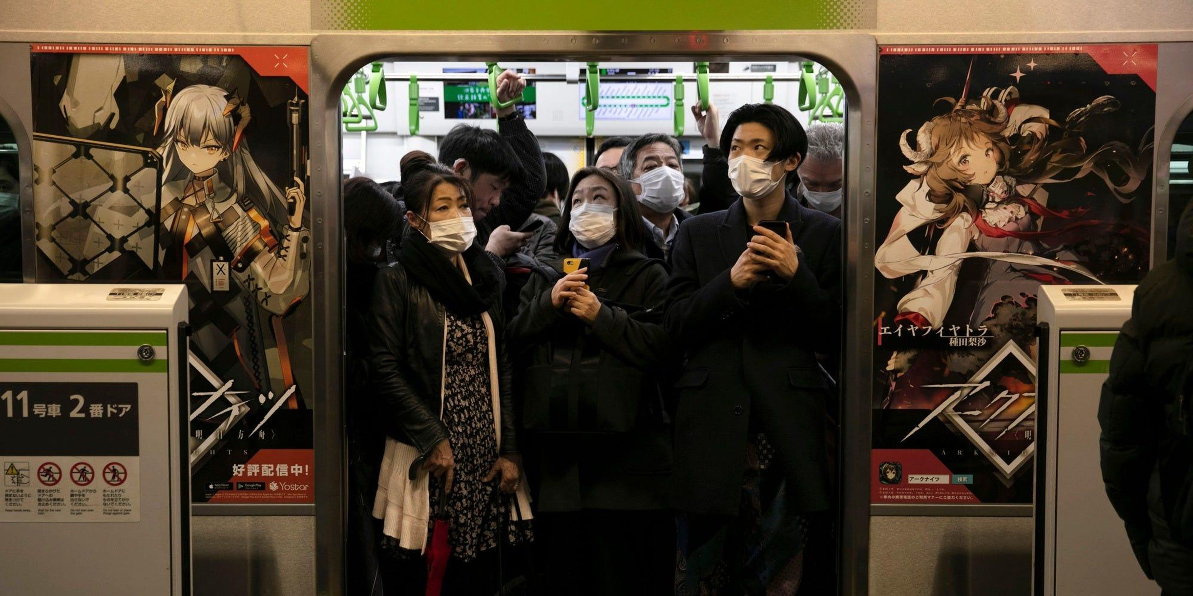 Gente desplazándose en transporte público con mascarillas en Tokio durante el coronavirus.