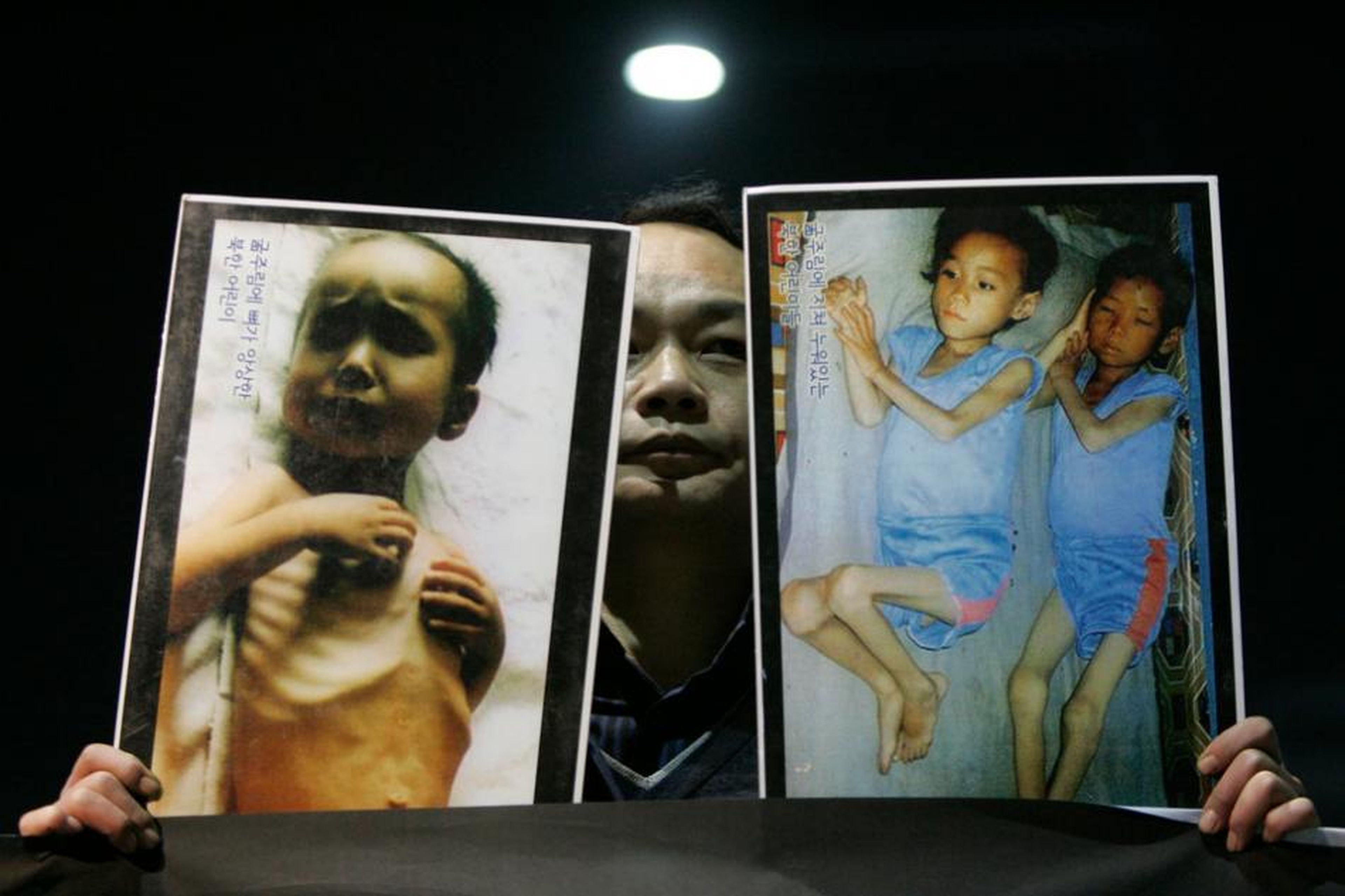 Un hombre surcoreano enseña unas fotografías en diciembre de 2009 que muestran, según su testimonio, cómo los niños norcoreanos se mueren de hambre.