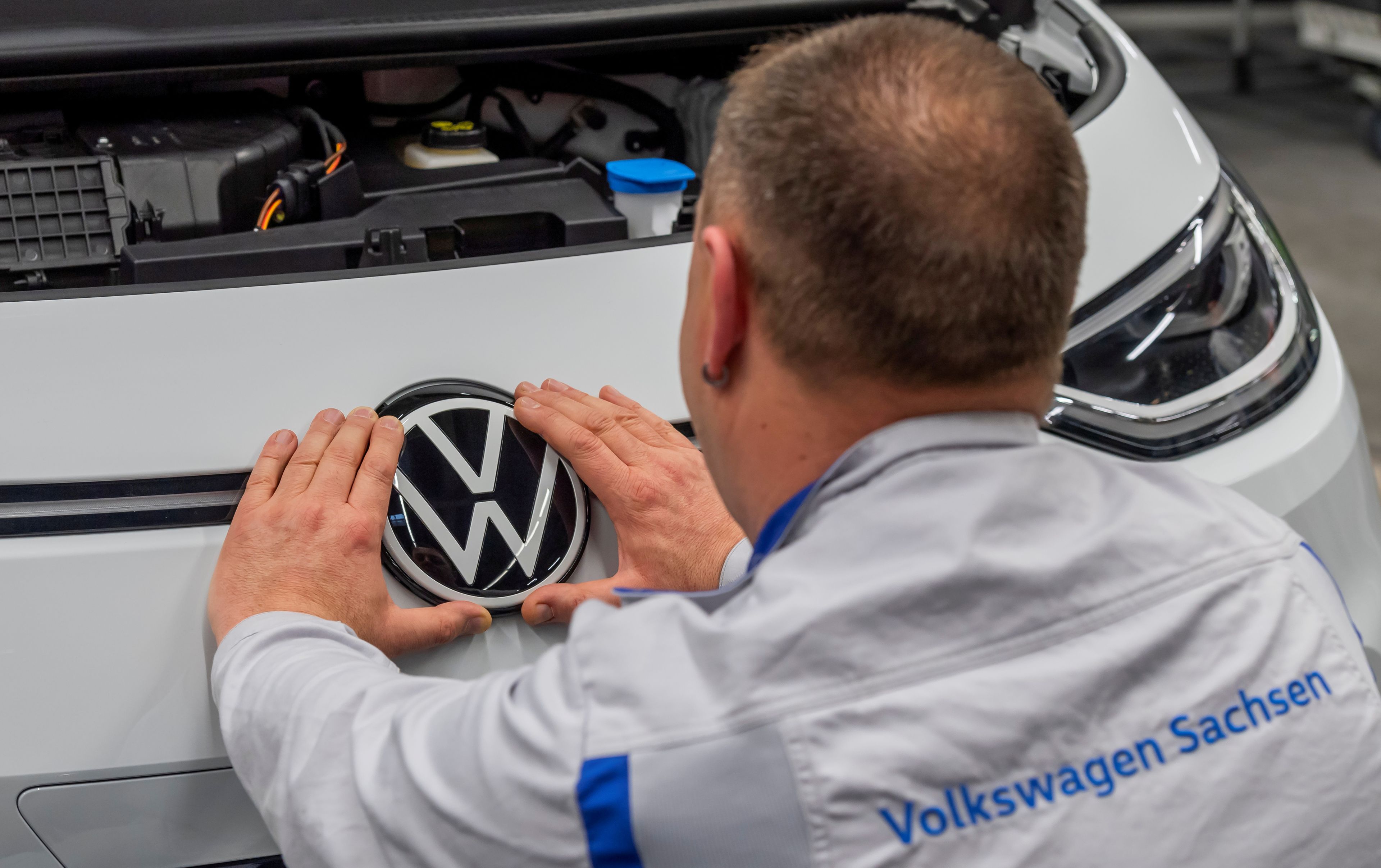 Un empleado coloca una placa de VW en una línea de producción en la planta de Zwickau.