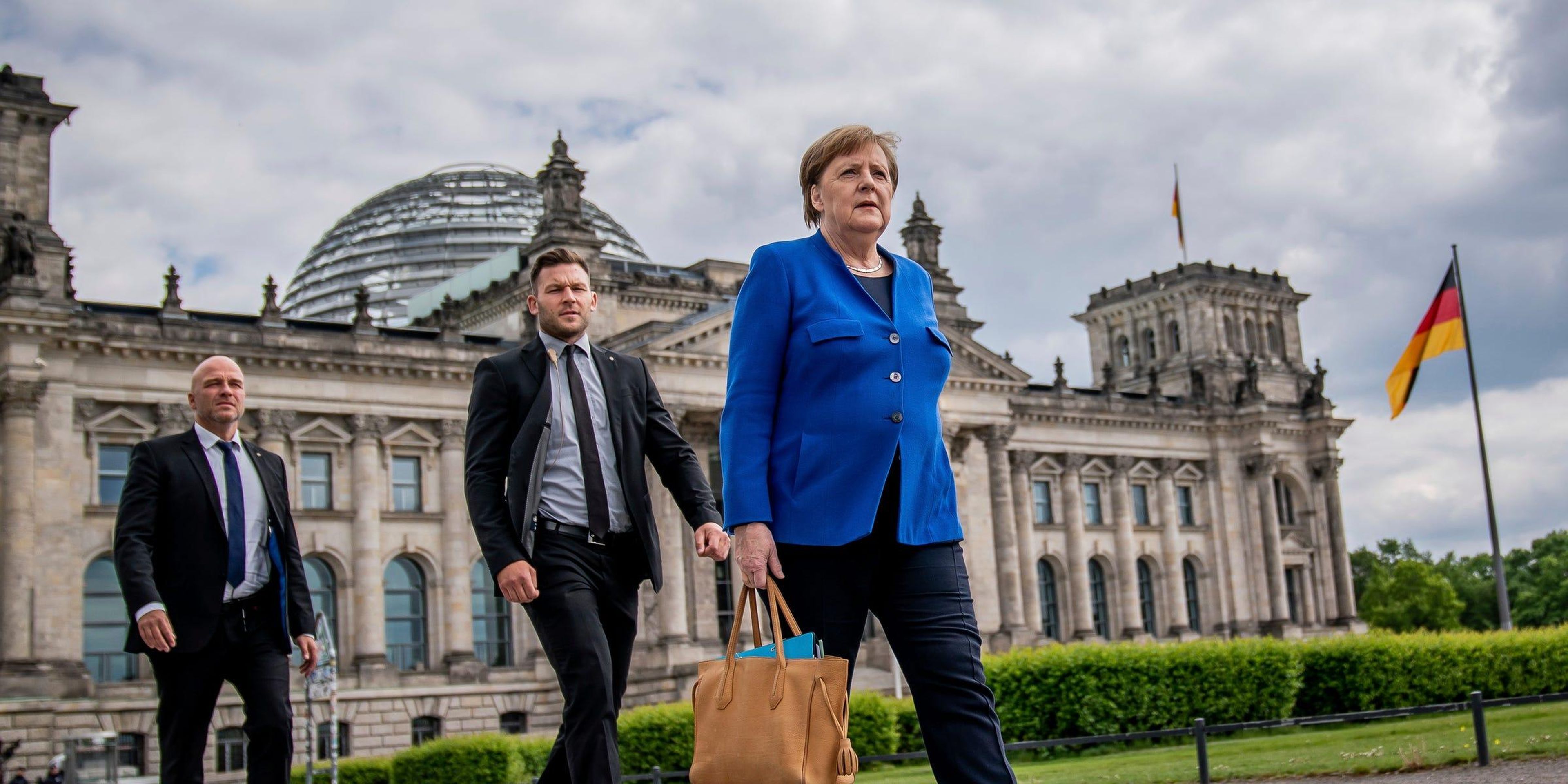 La canciller alemana Angela Merkel pasea con sus guardaespaldas por Berlín.