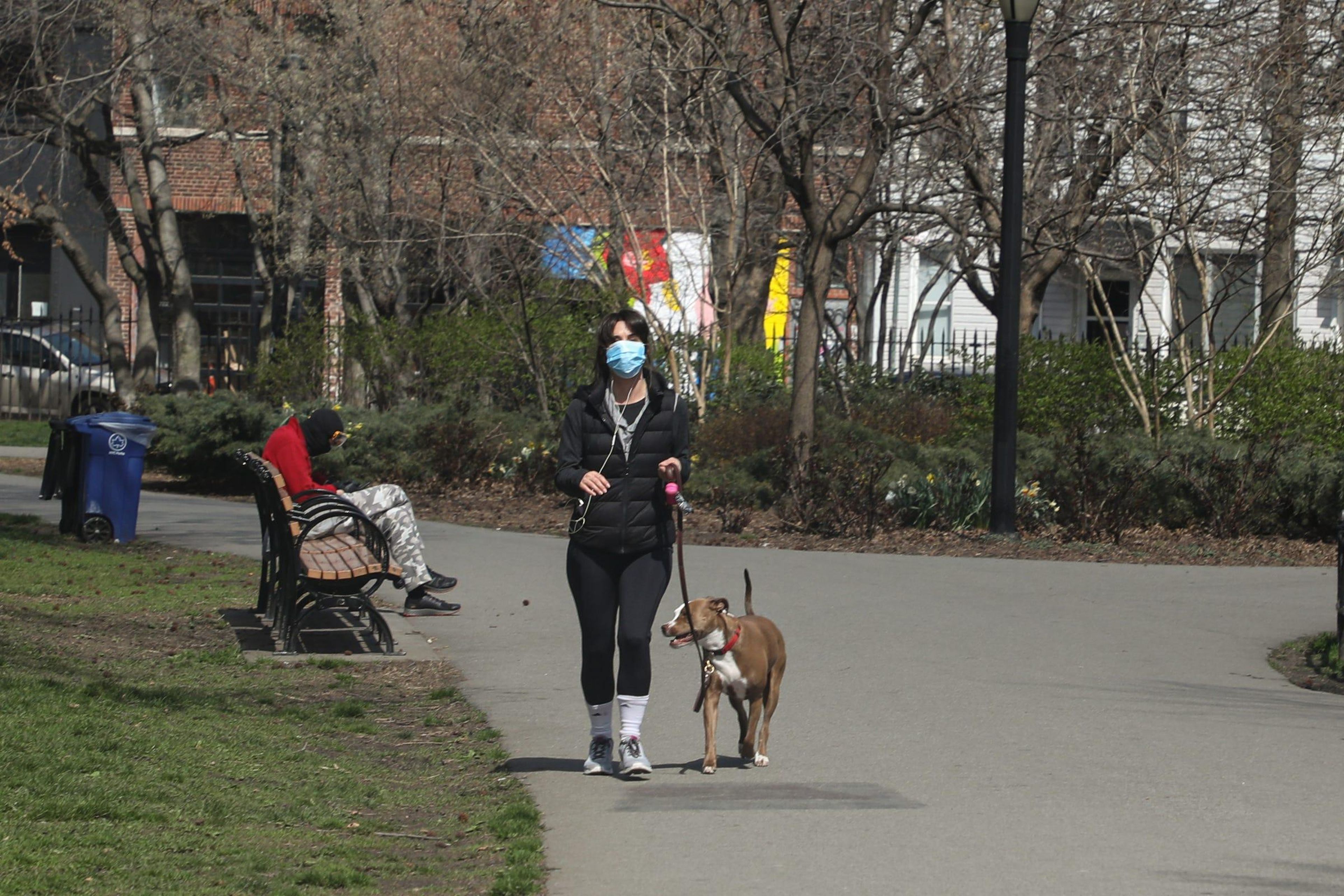 Una mujer pasea con su perro durante la pandemia de coronavirus.