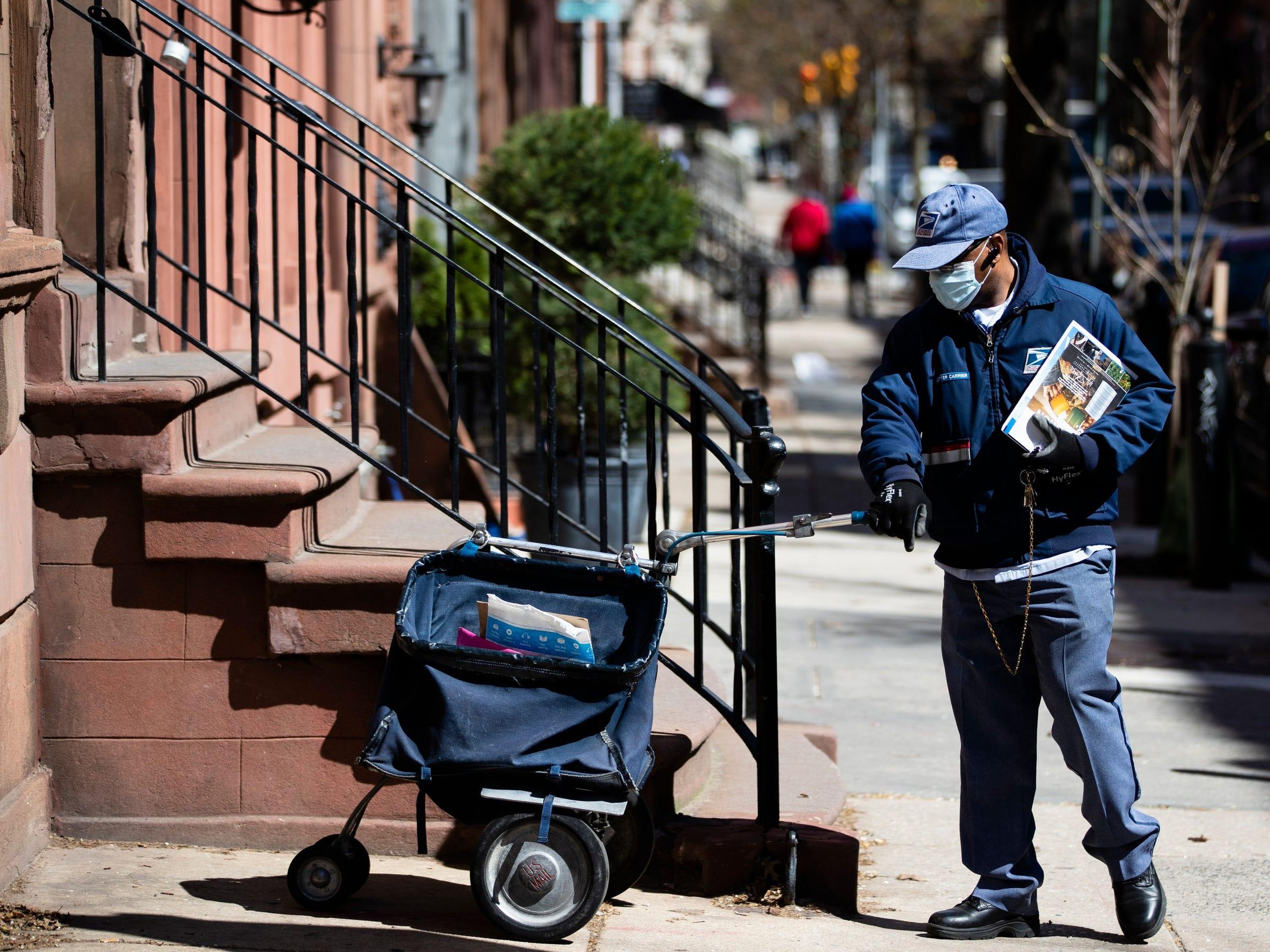 A United States Postal Service worker delivering mail in Philadelphia on April 2.