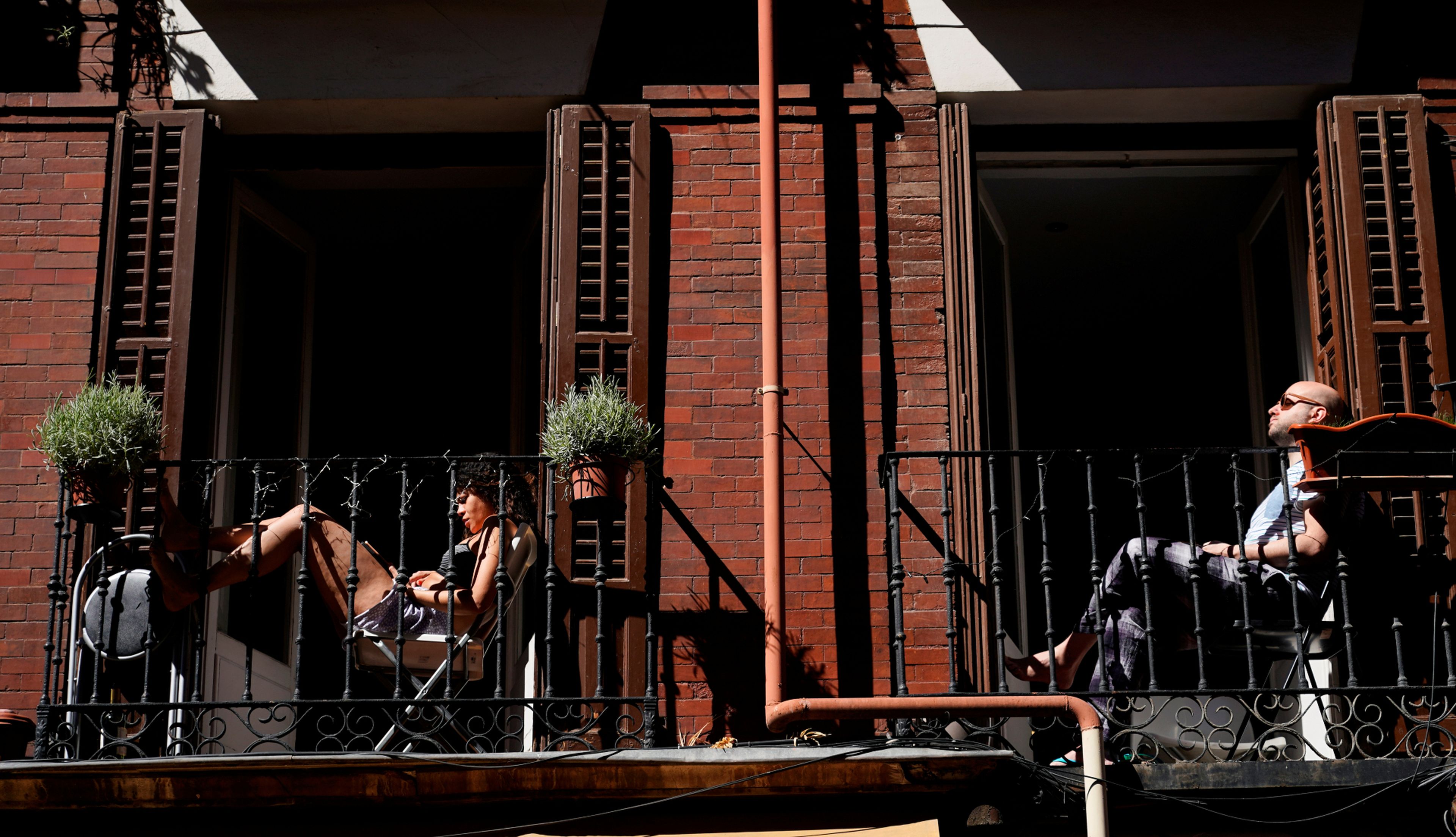 Madrileños toman el sol en las terrazas de sus pisos durante el confinamiento