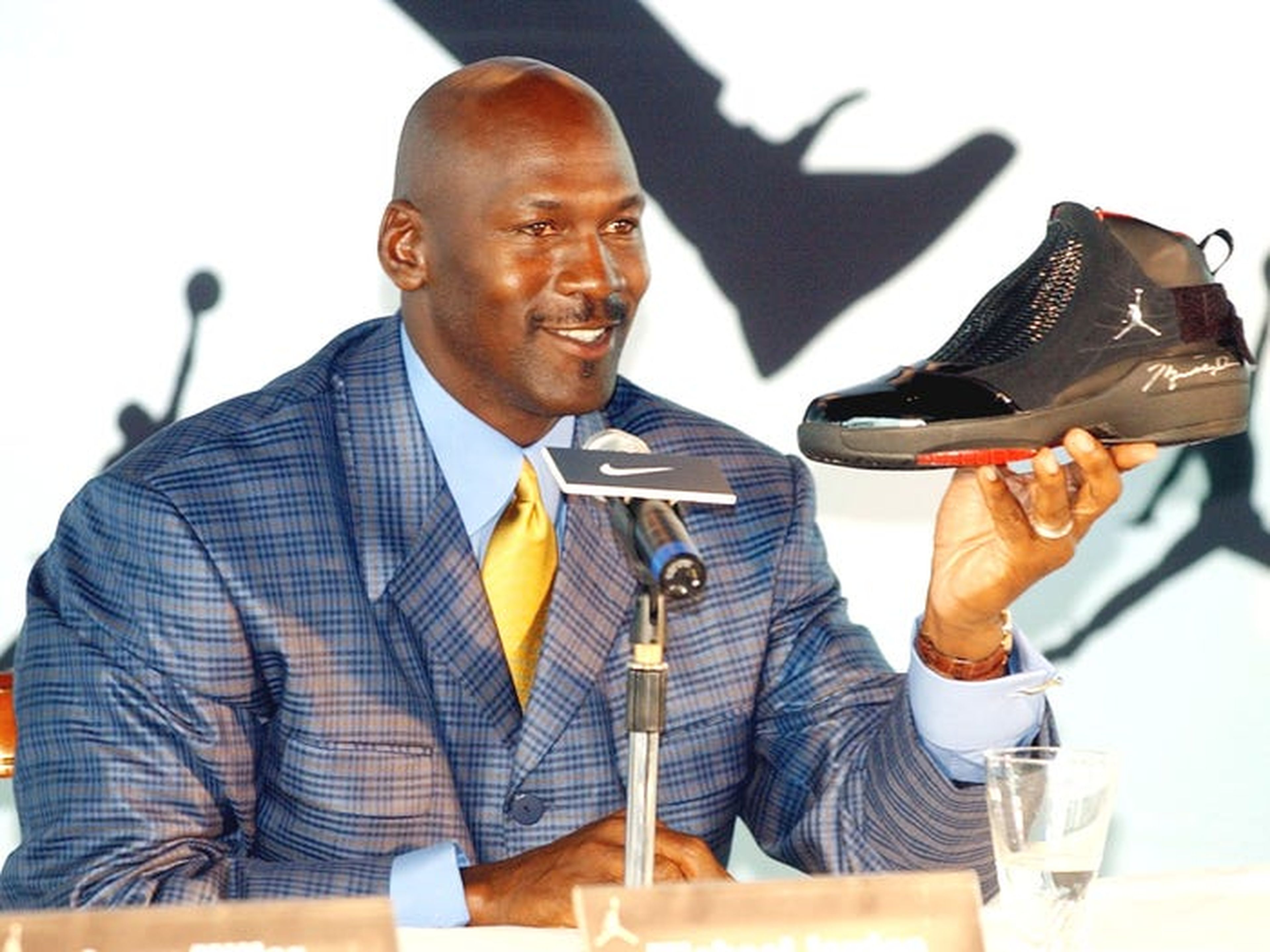 La leyenda de la NBA Michael Jordan sostiene una zapatilla AJ19 autografiado, el último diseño de la línea Air Jordan, en una conferencia de prensa en Hong Kong.