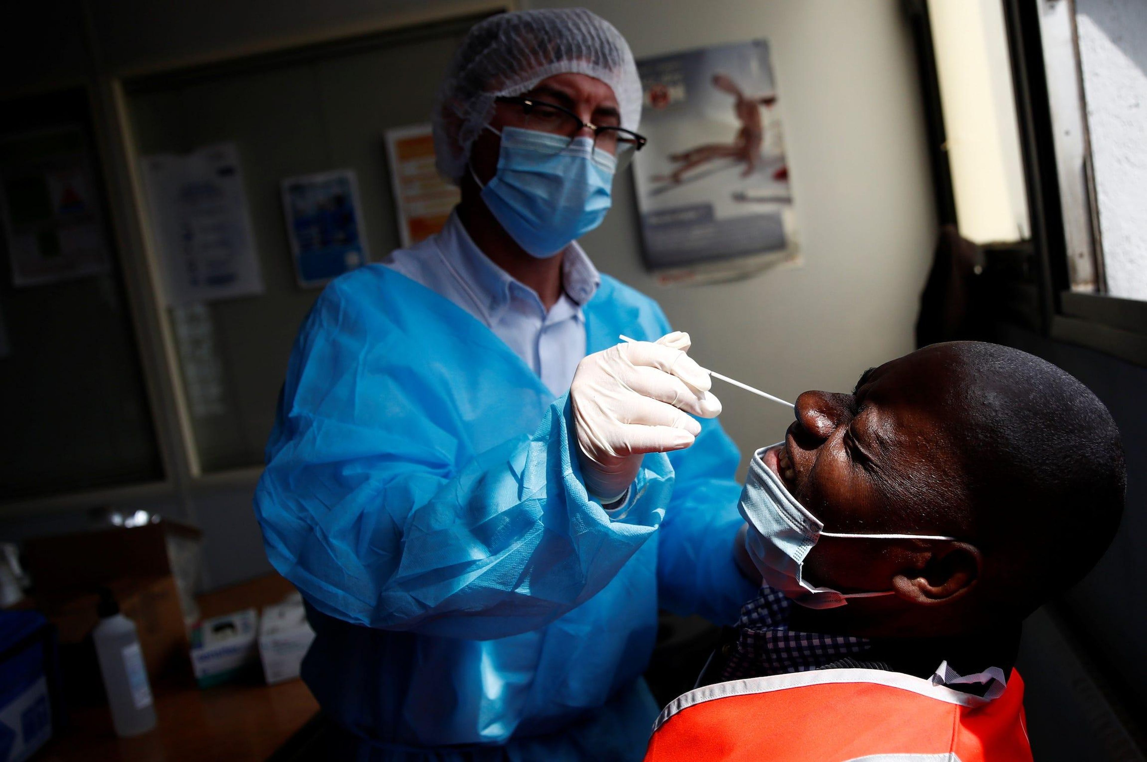 Un biólogo médico administra un hisopo nasal a un recolector de basura durante una operación de prueba de COVID-19 en el sitio de recolección de desechos de Veolia, cerca de París, Francia, el 7 de mayo de 2020.