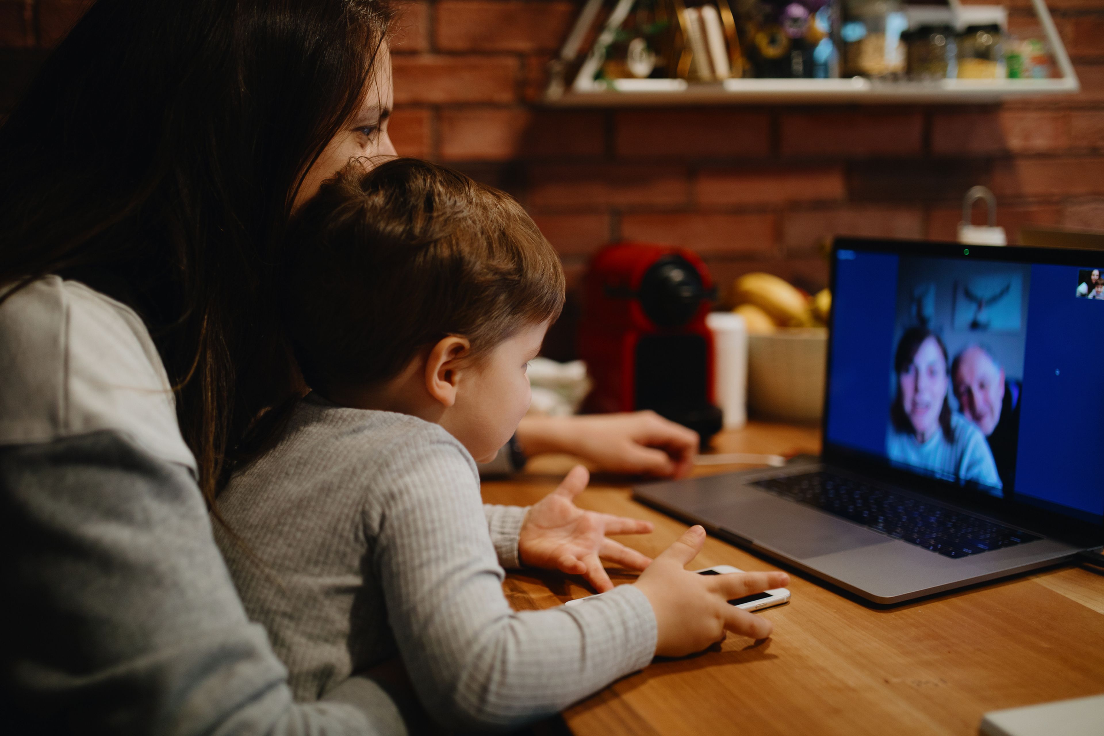 Mujer y niño hablando por webcam