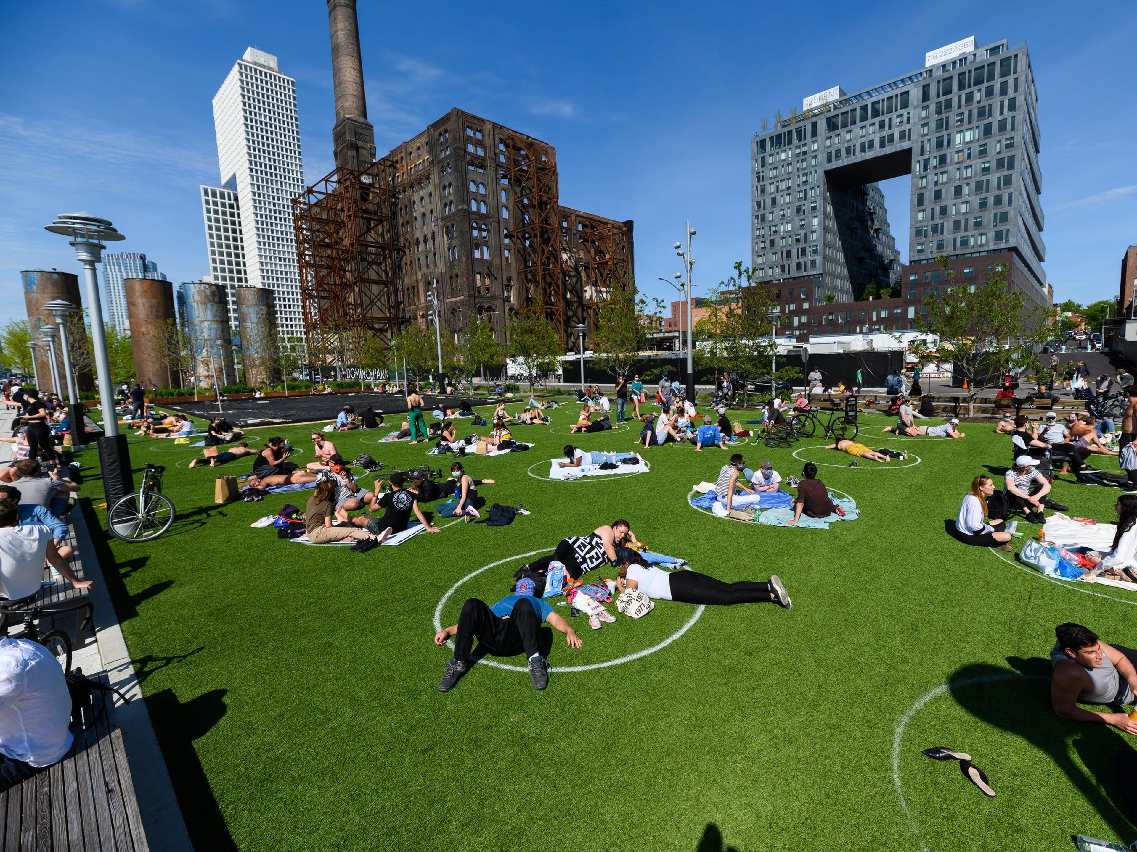 Neoyorquinos en círculos de distanciamiento social en Domino Park en Brooklyn, Nueva York.
