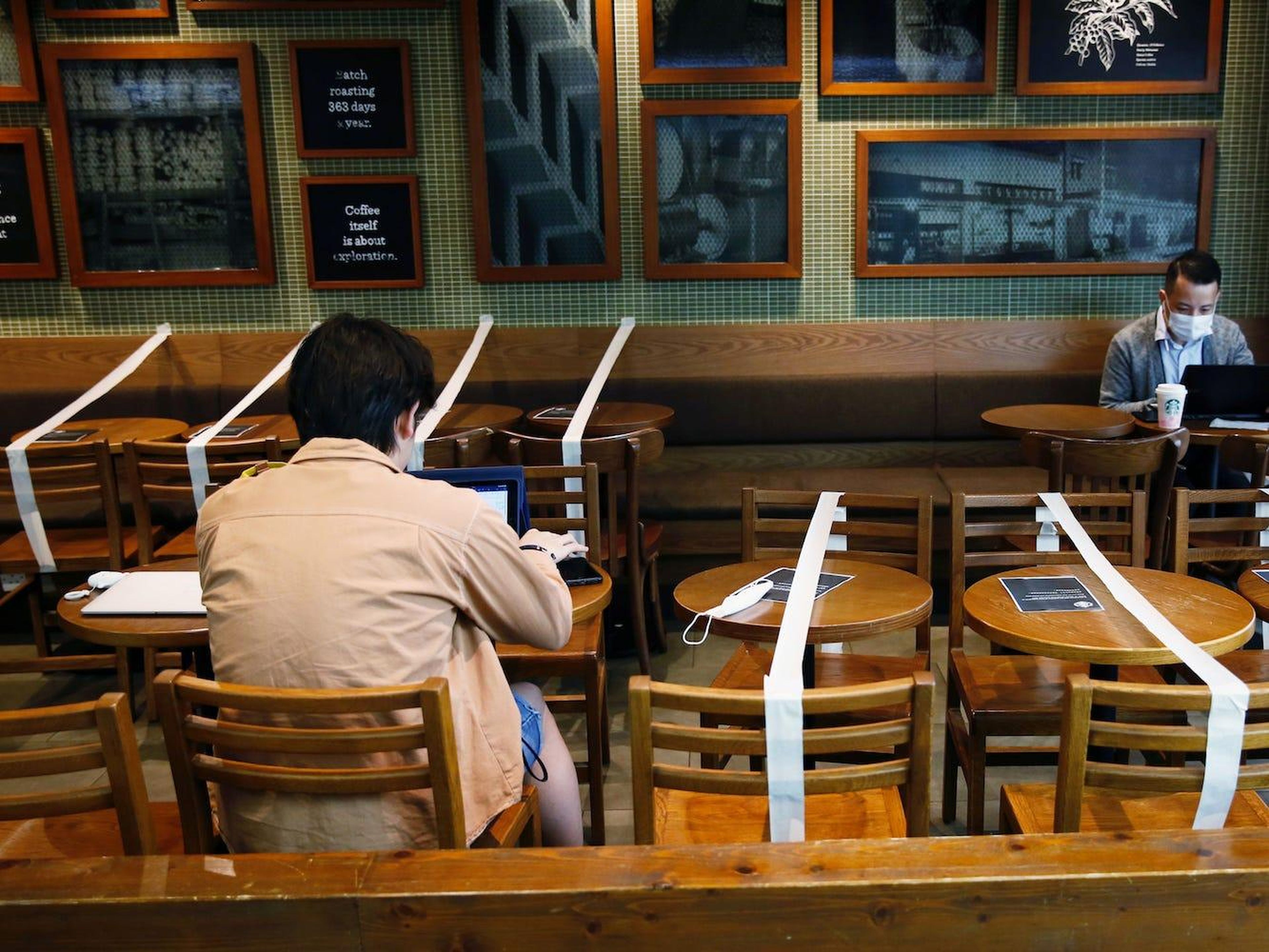 Mesas y sillas con cinta adhesiva para mantener el distanciamiento social en una cafetería Starbucks en Hong Kong, el 2 de abril de 2020.