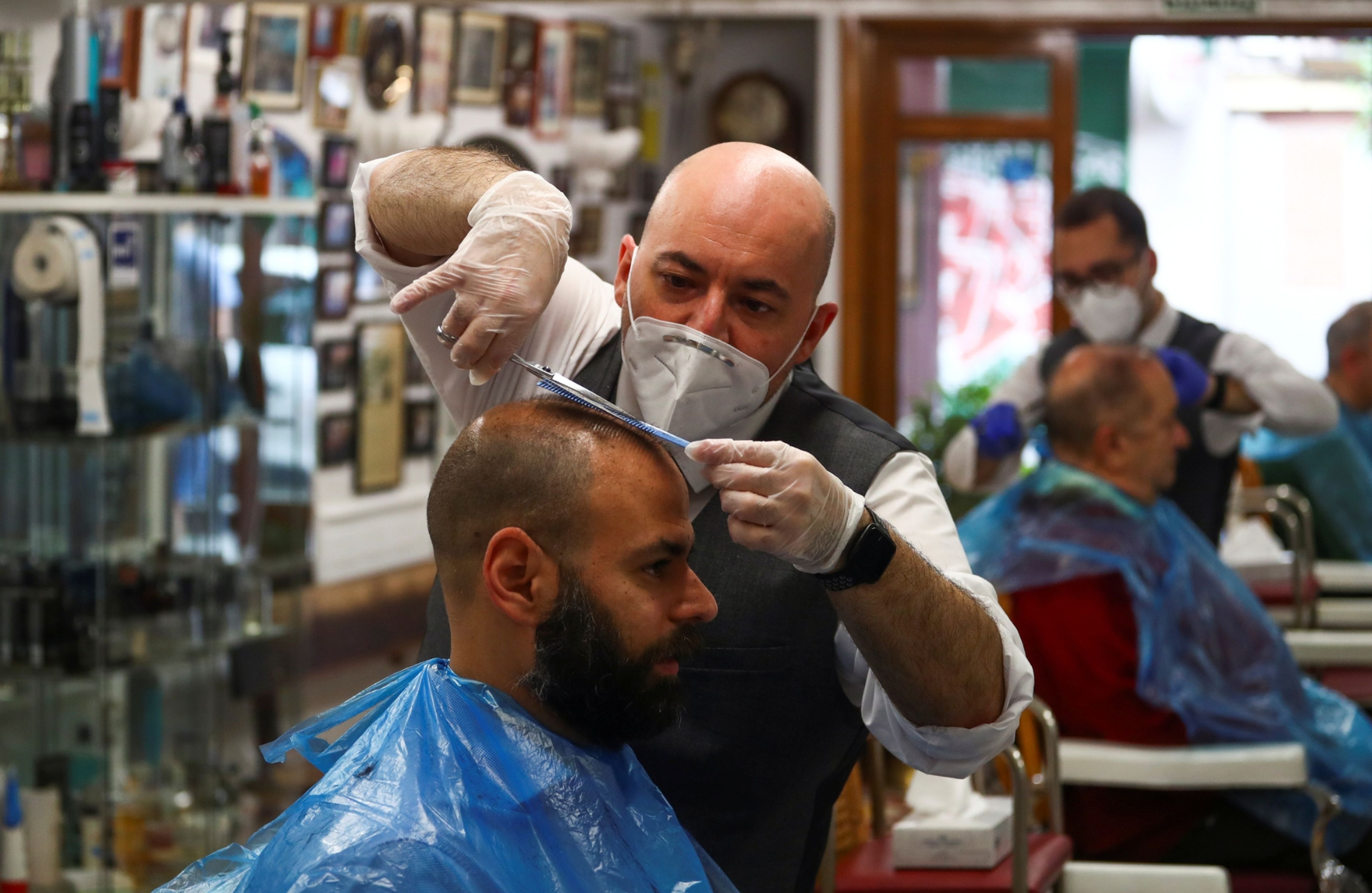 Un peluquero en su peluquería en la desescalada del coronavirus en España