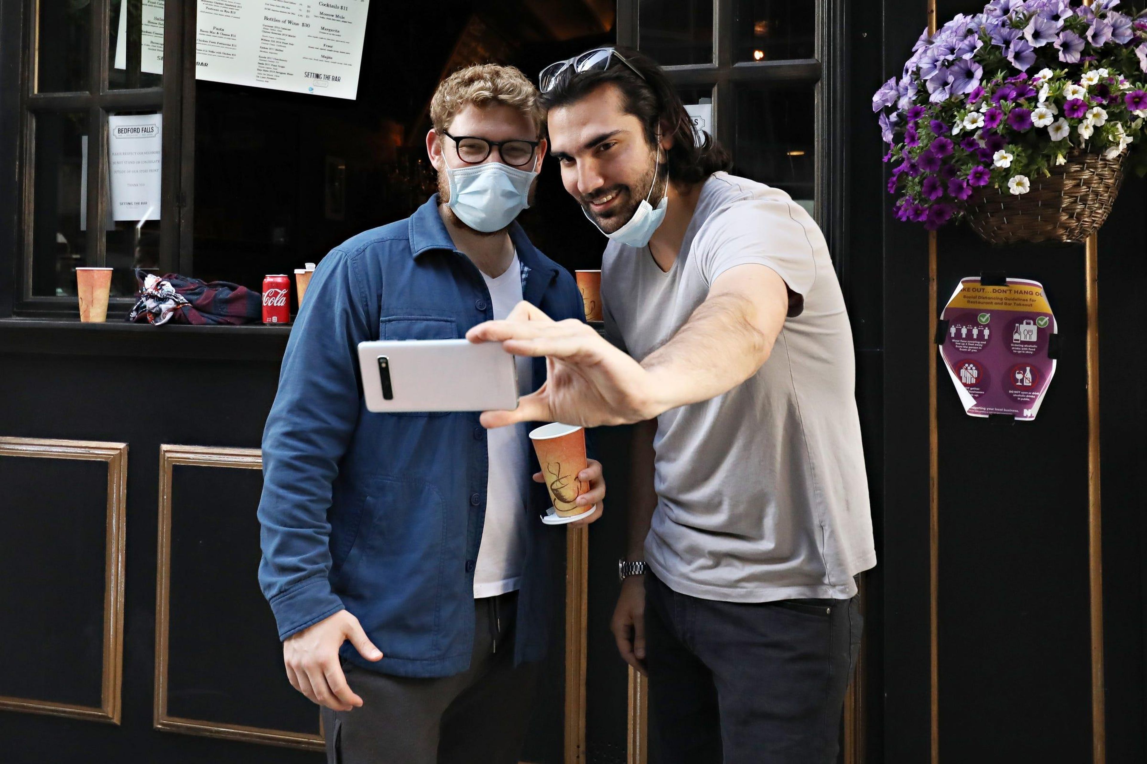 Personas que llevan mascarillas posan para un selfie durante la pandemia de coronavirus el 27 de mayo de 2020 en la ciudad de Nueva York.