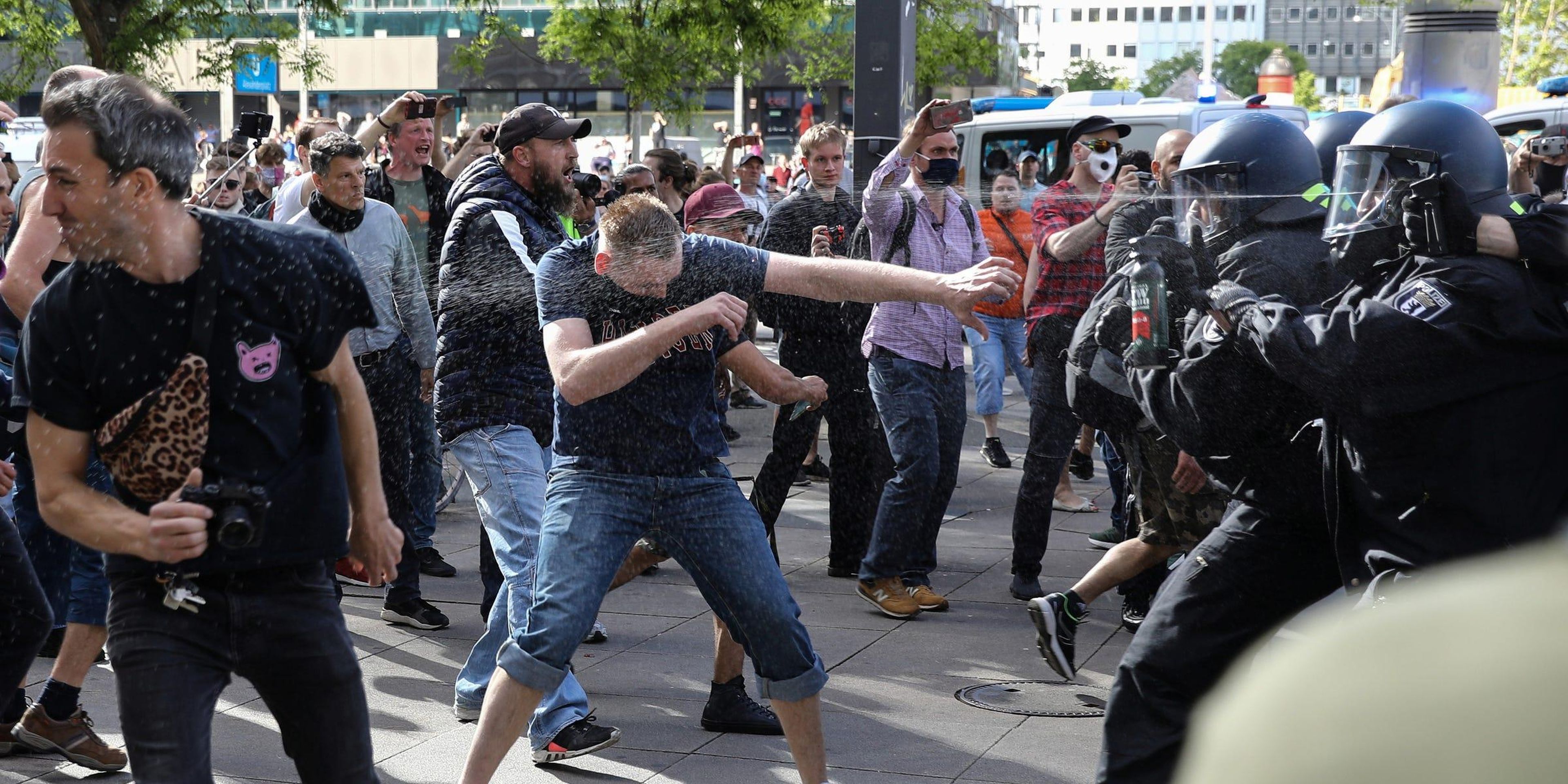 Oficiales de policía rocían con gas pimienta a manifestantes en Berlín, Alemania, el 9 de mayo de 2020.