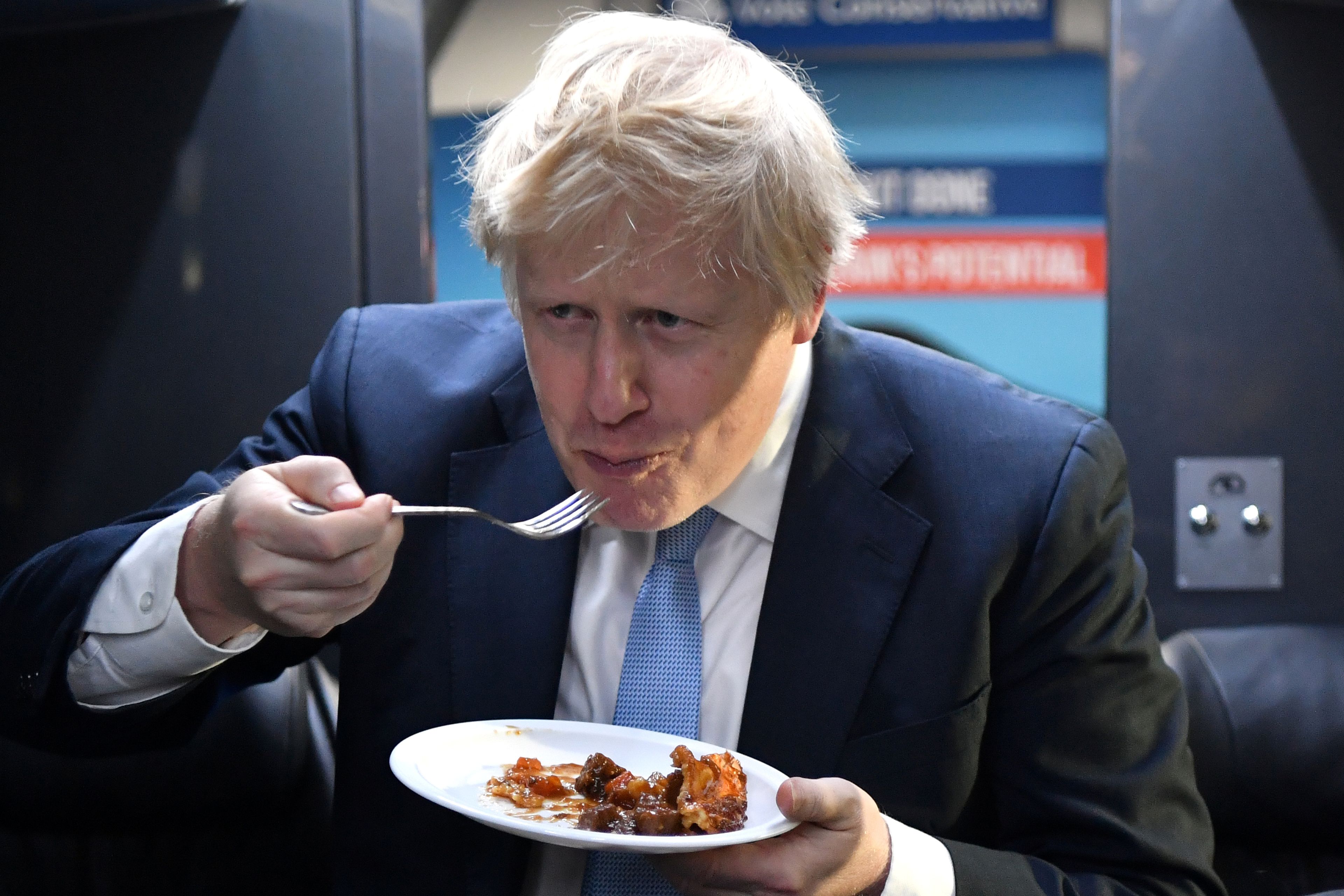 El primer ministro británico, Boris Johnson, come una porción de pastel en el autobús de campaña.