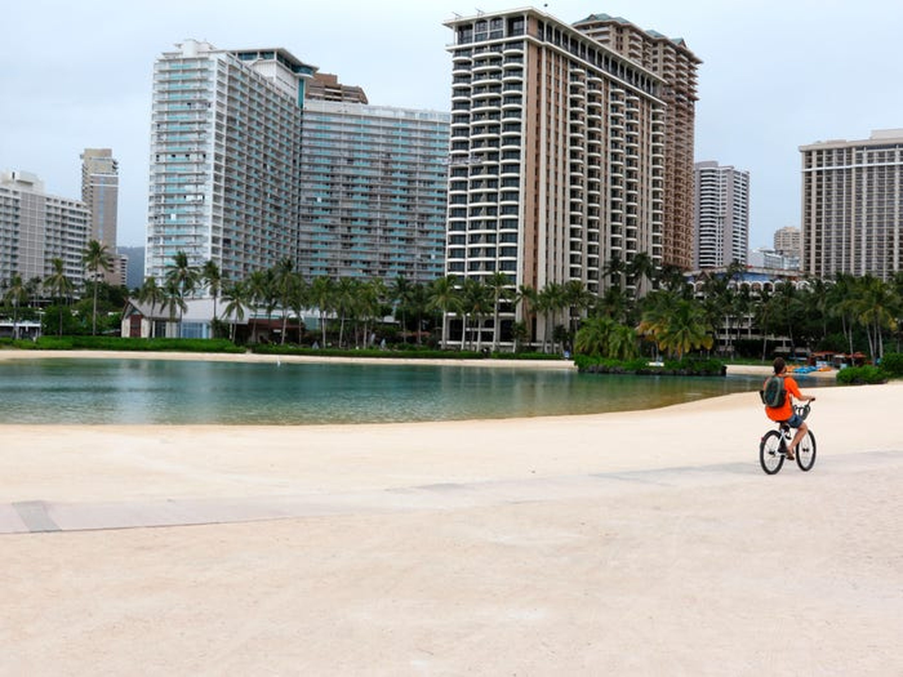 En esta foto del 21 de abril de 2020, un hombre monta su bicicleta en la playa de Waikiki en Honolulu.