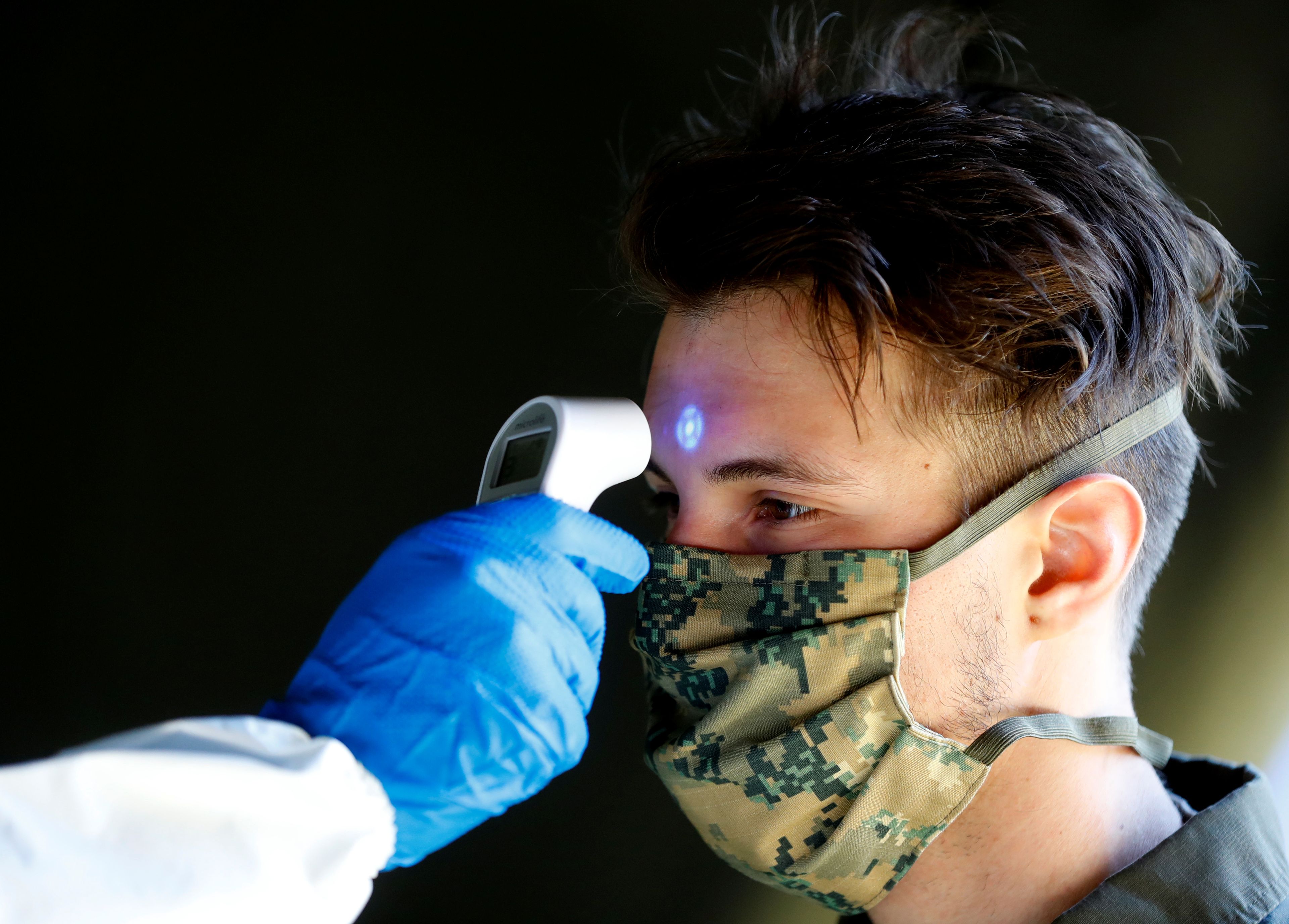 Un soldado del ejército austriaco toma la temperatura a un compañero durante la crisis del coronavirus en Viena
