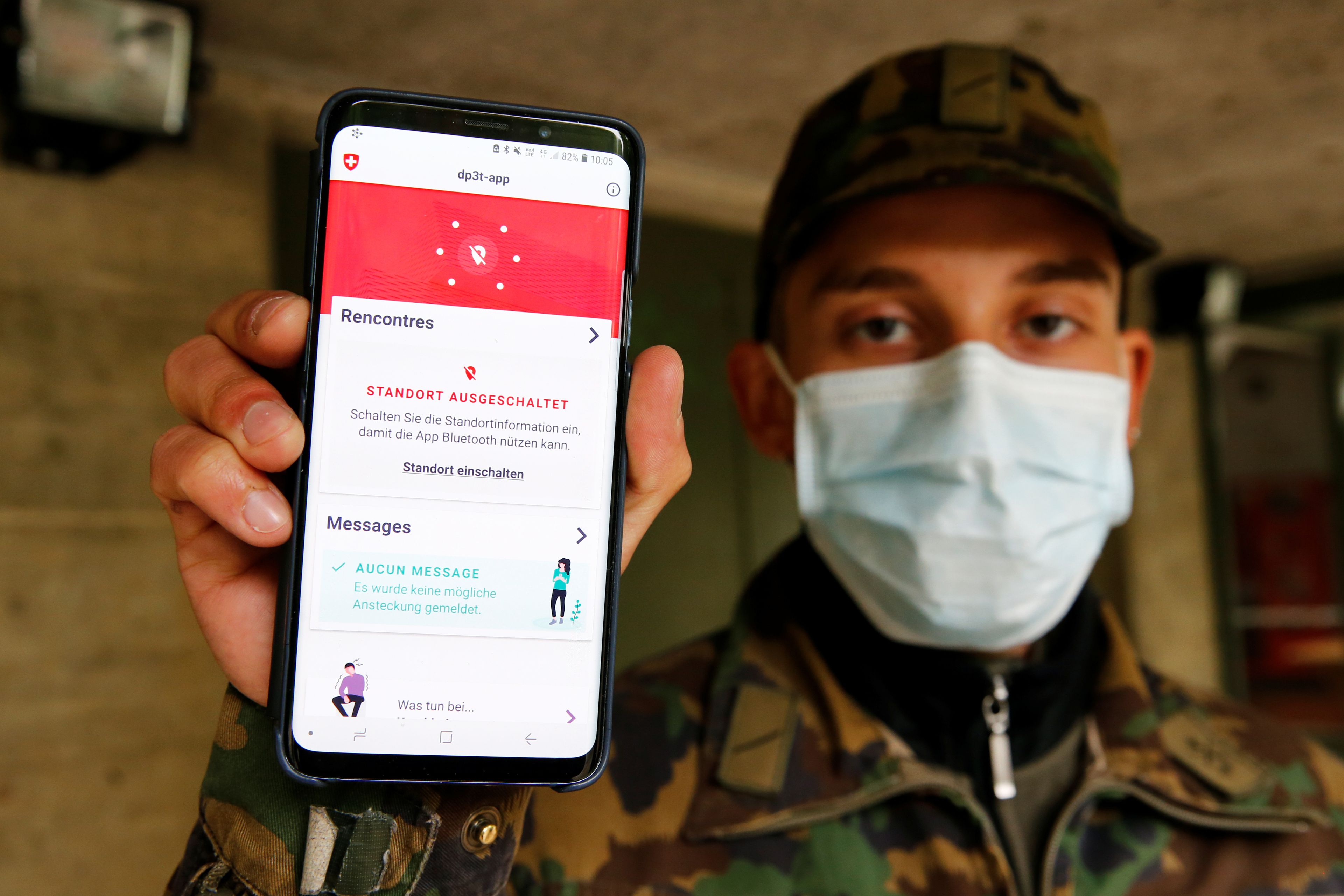 Un soldado suizo enseña la app de rastreo de contactos.