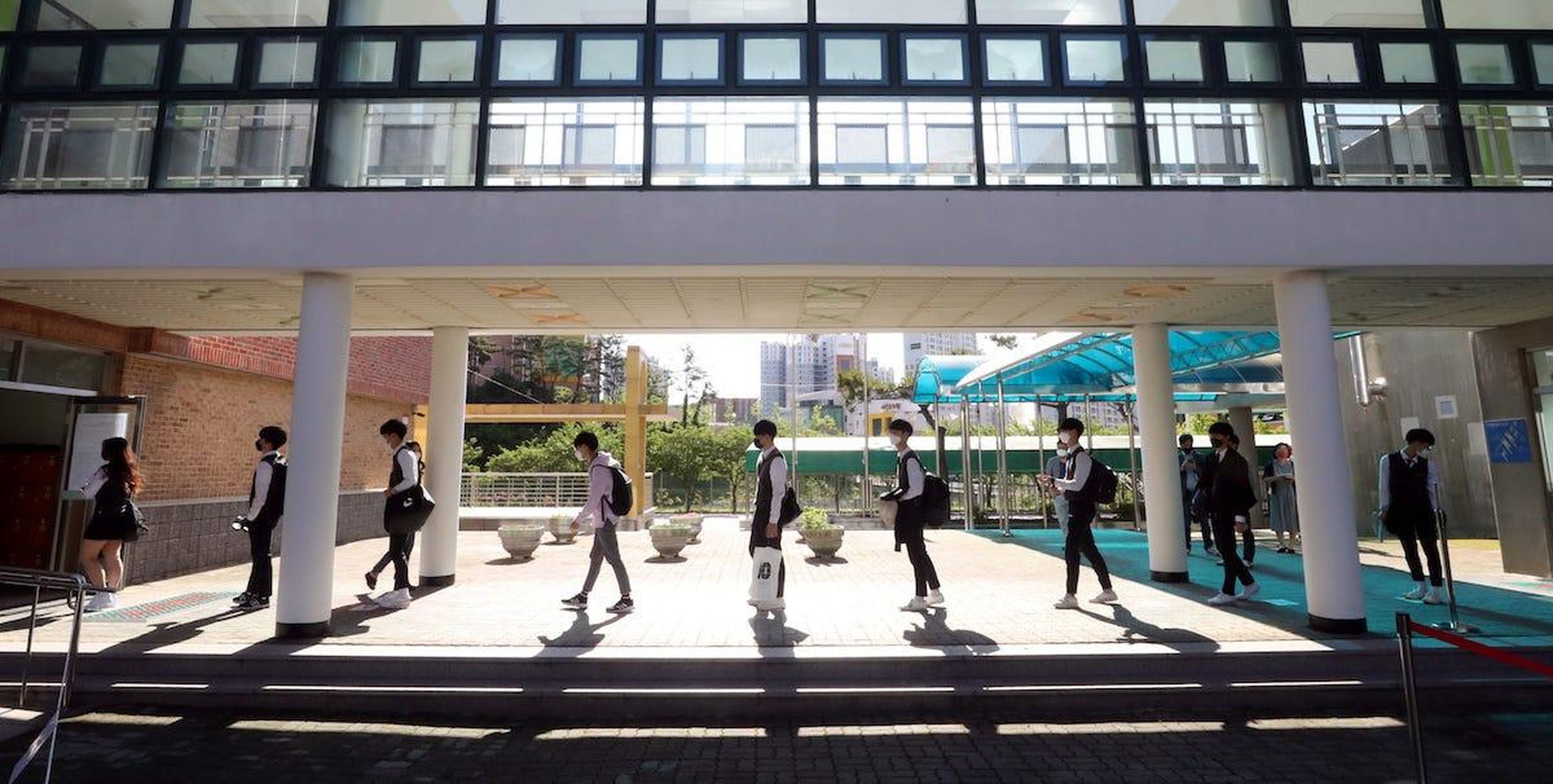 Estudiantes usando mascarilla haciendo cola para ingresar en un instituto de Ulsan, 20 de mayo de 2020.