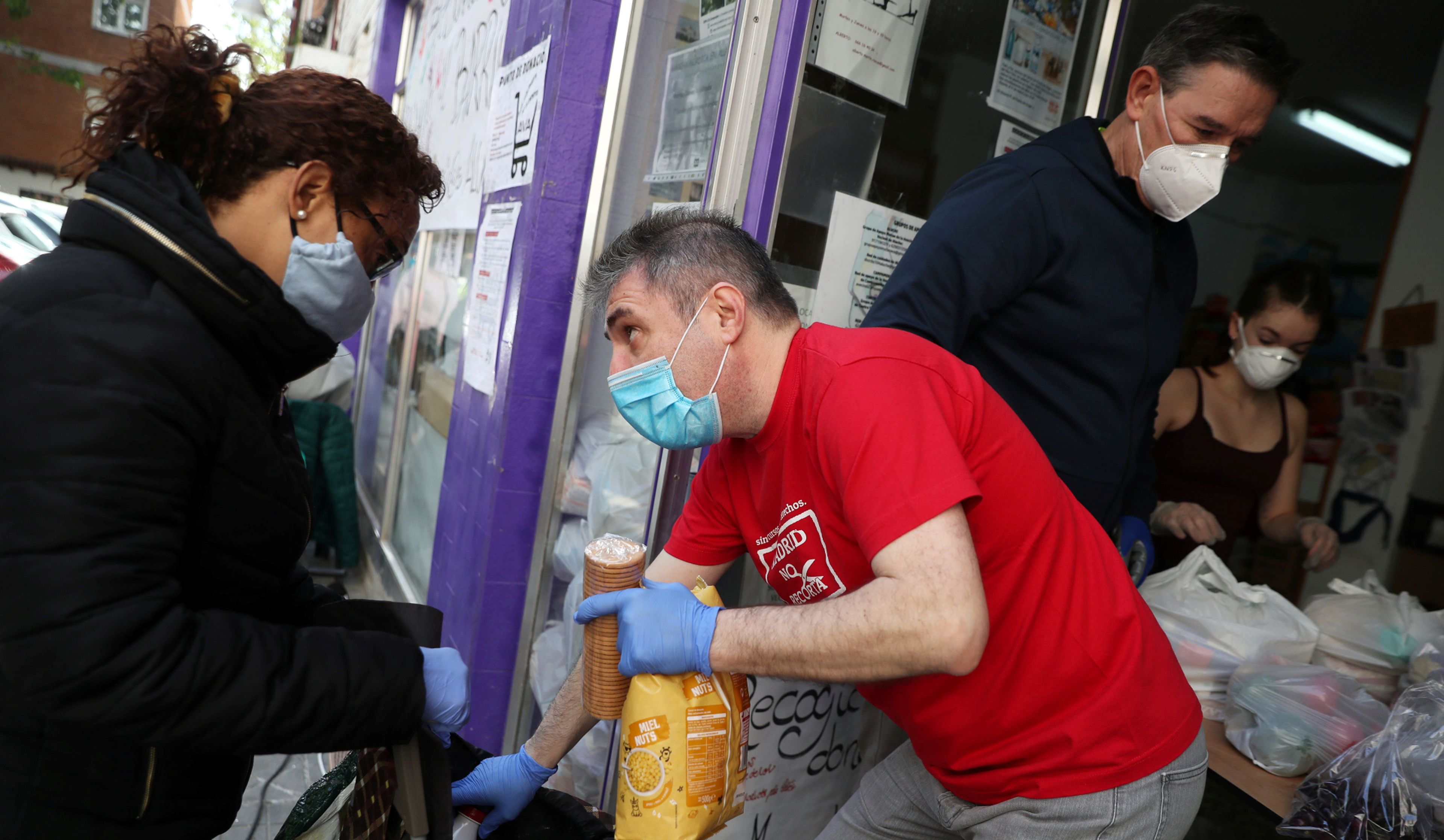Voluntarios reparten comida a familias sin recursos en la asociación de vecinos de Aluche (Madrid)