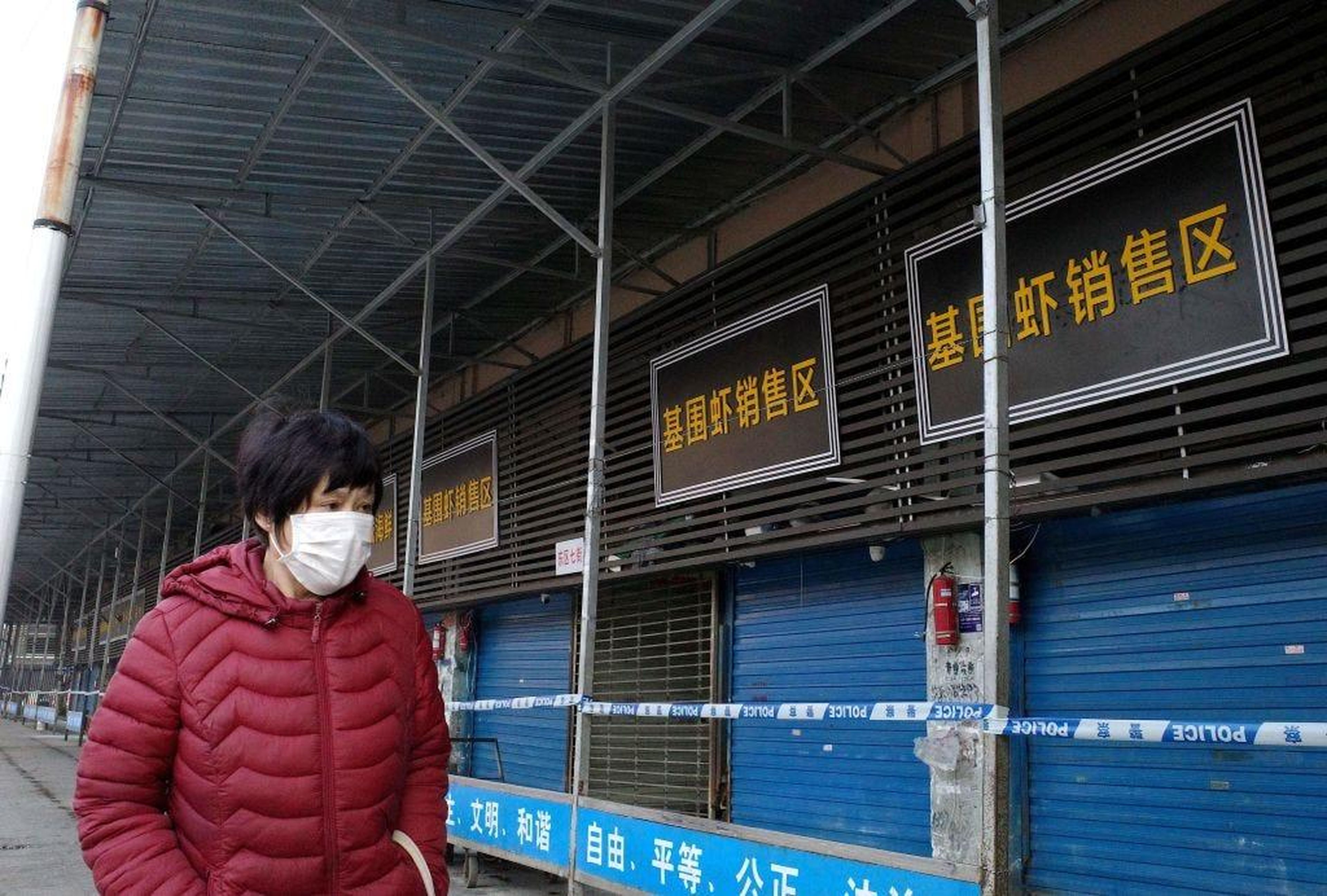 Una mujer camina frente al mercado callejero de Huanan cerrado el 12 de enero de 2020.