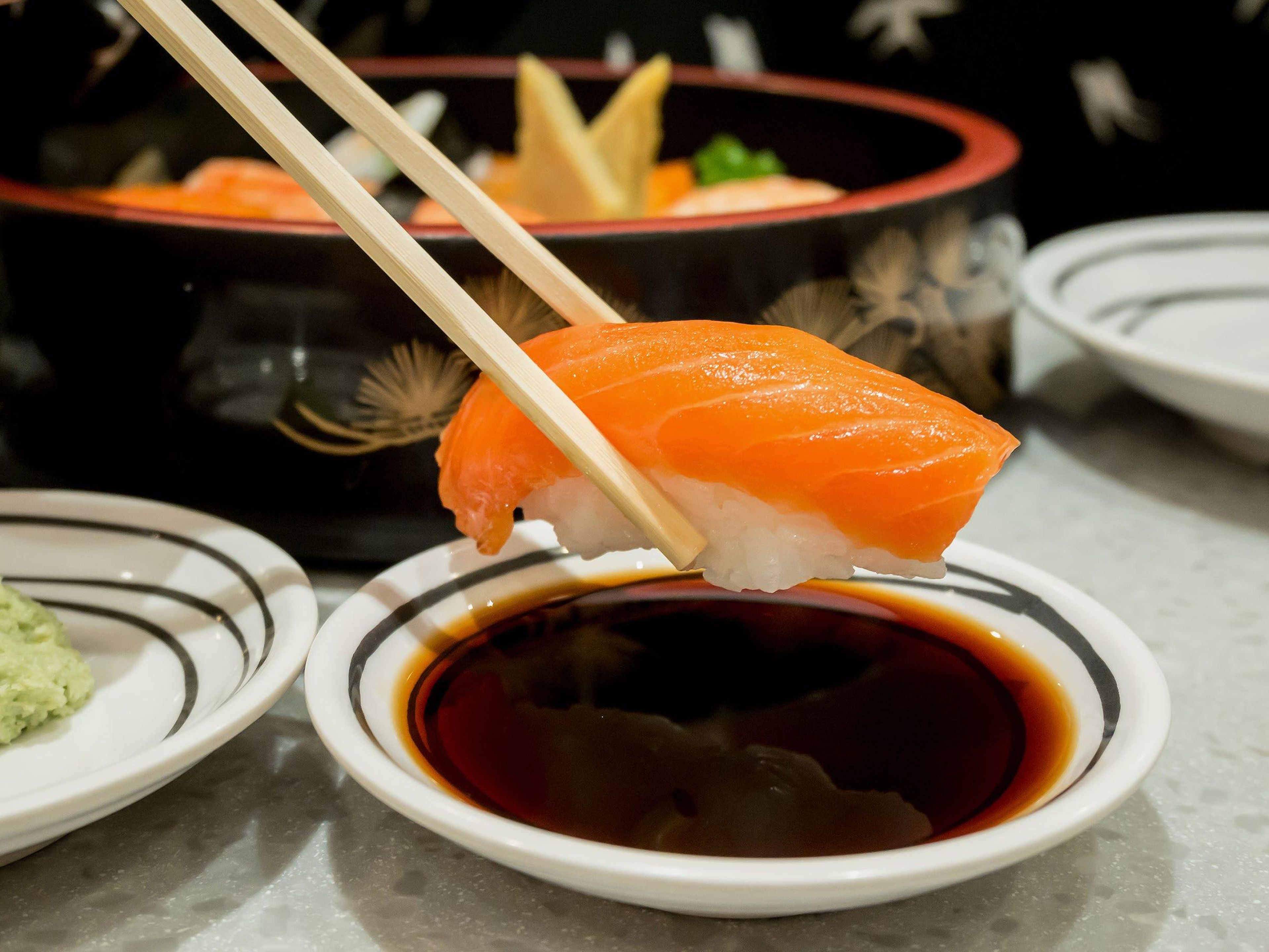 Esta imagen muestra la forma incorrecta de sumergir el sushi en la salsa.