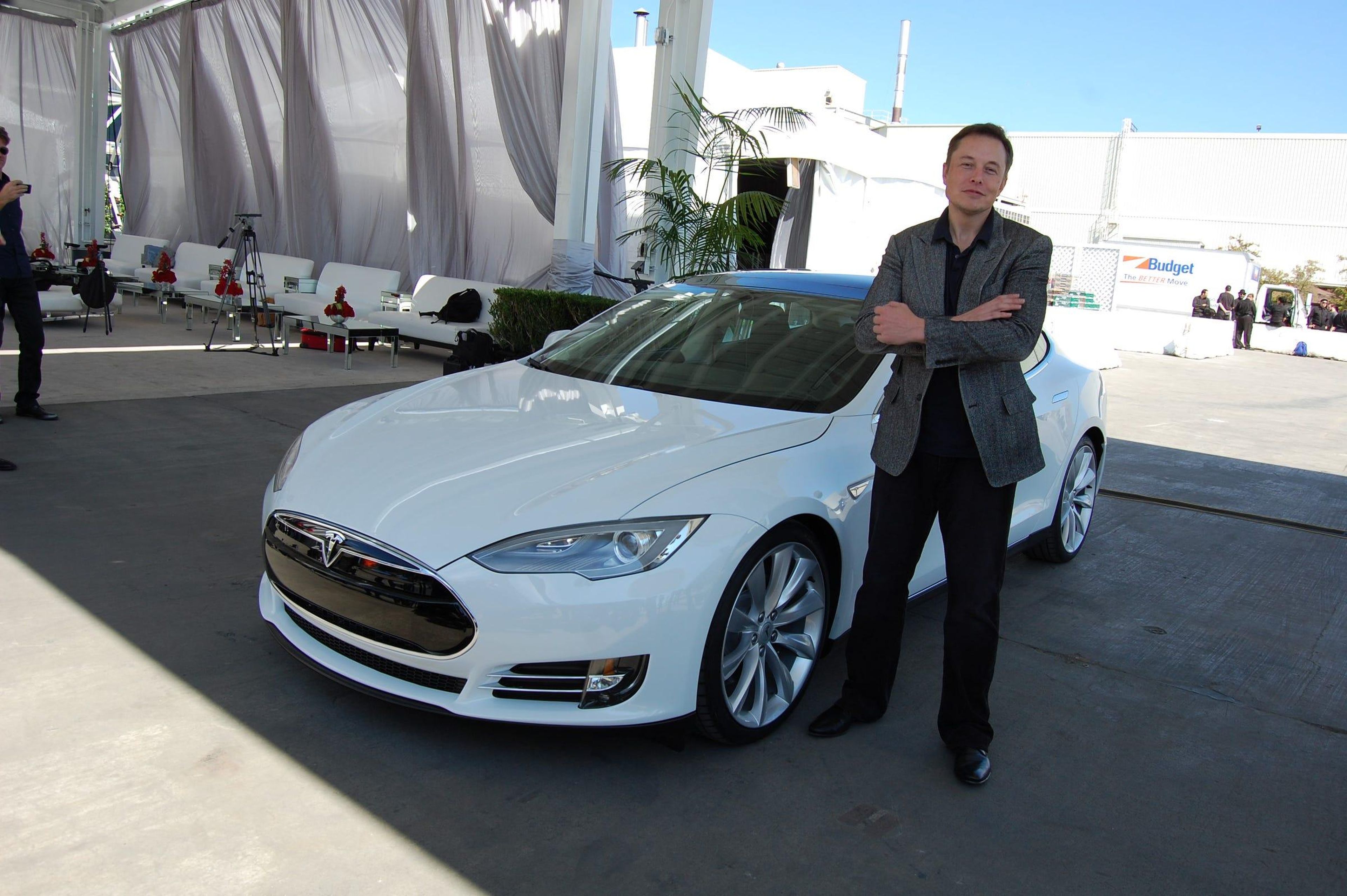 Elon Musk al lado de un Tesla Model S.