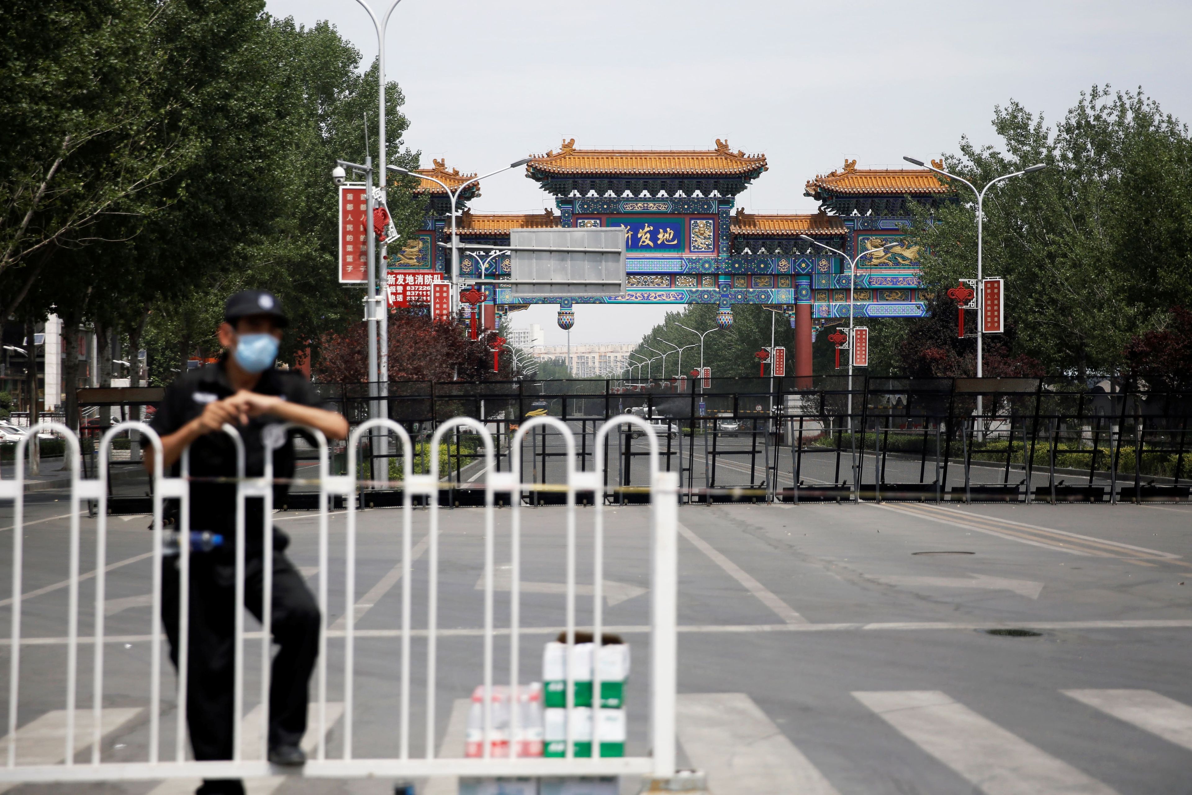 Un oficial de seguridad bloquea la entrada al mercado mayorista de Xinfadi en Pekín.