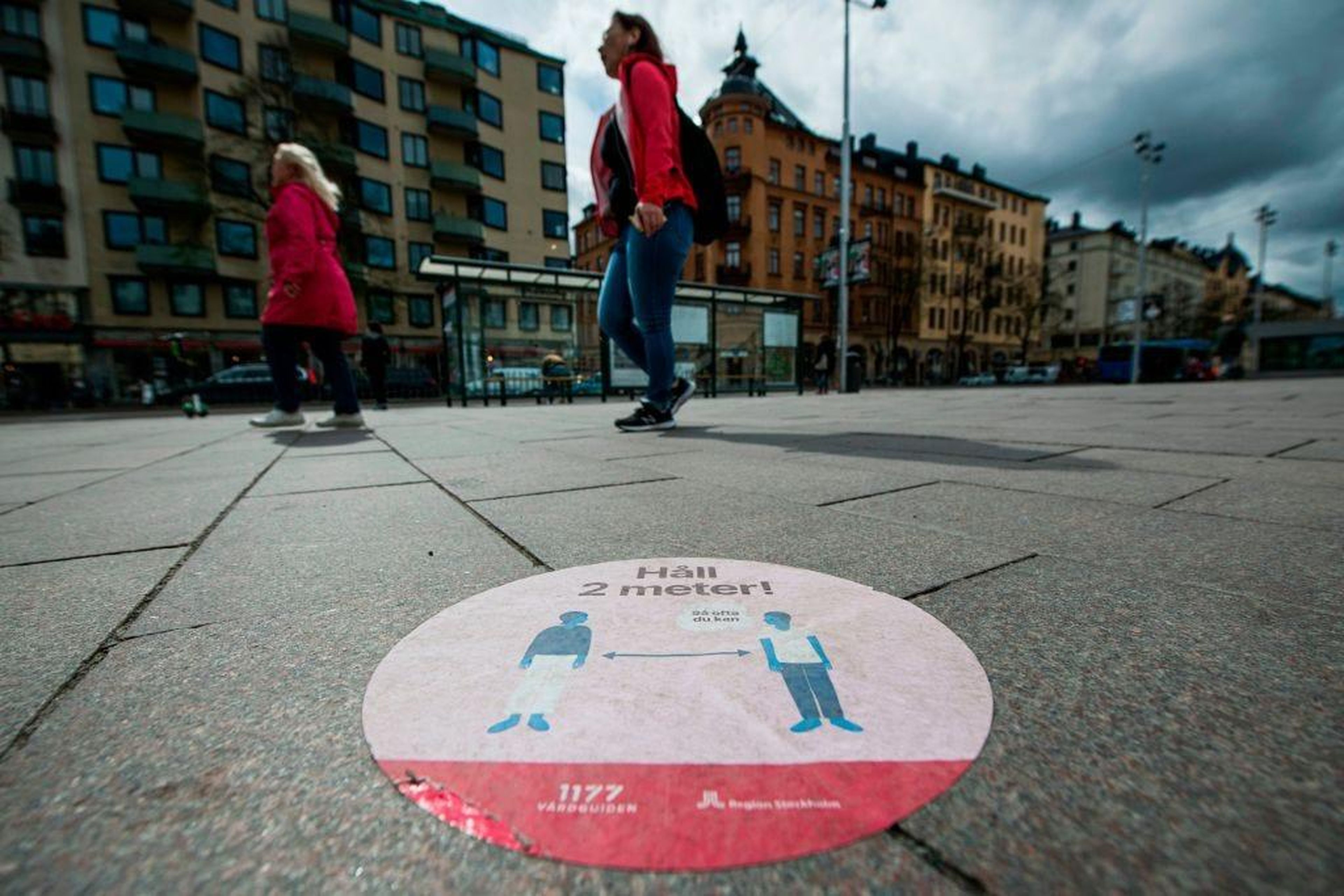 Una señal de los servicios de atención médica de Suecia en el suelo del centro de Estocolmo para indicar a las personas que mantengan la distancia de seguridad.
