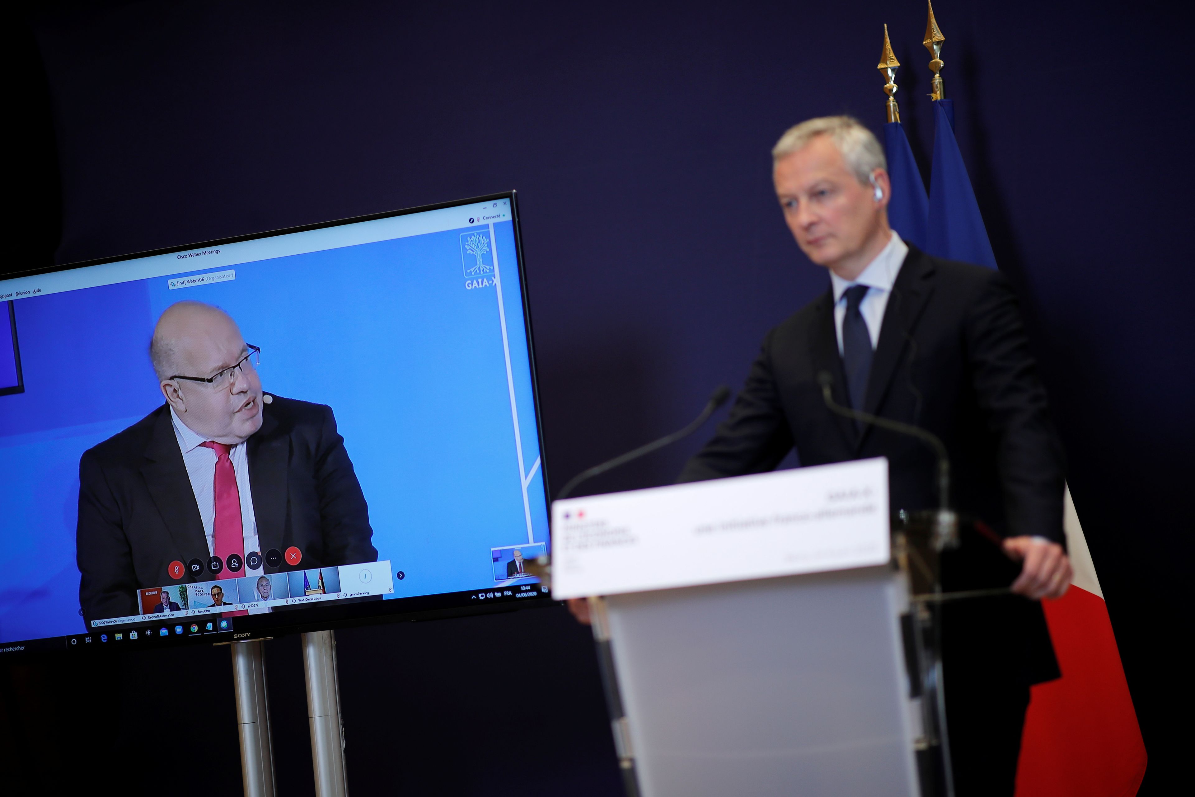El ministro alemán de Finanzas en la pantalla (i), Peter Altmaier; junto con su homólogo francés, Bruno Le Maire.