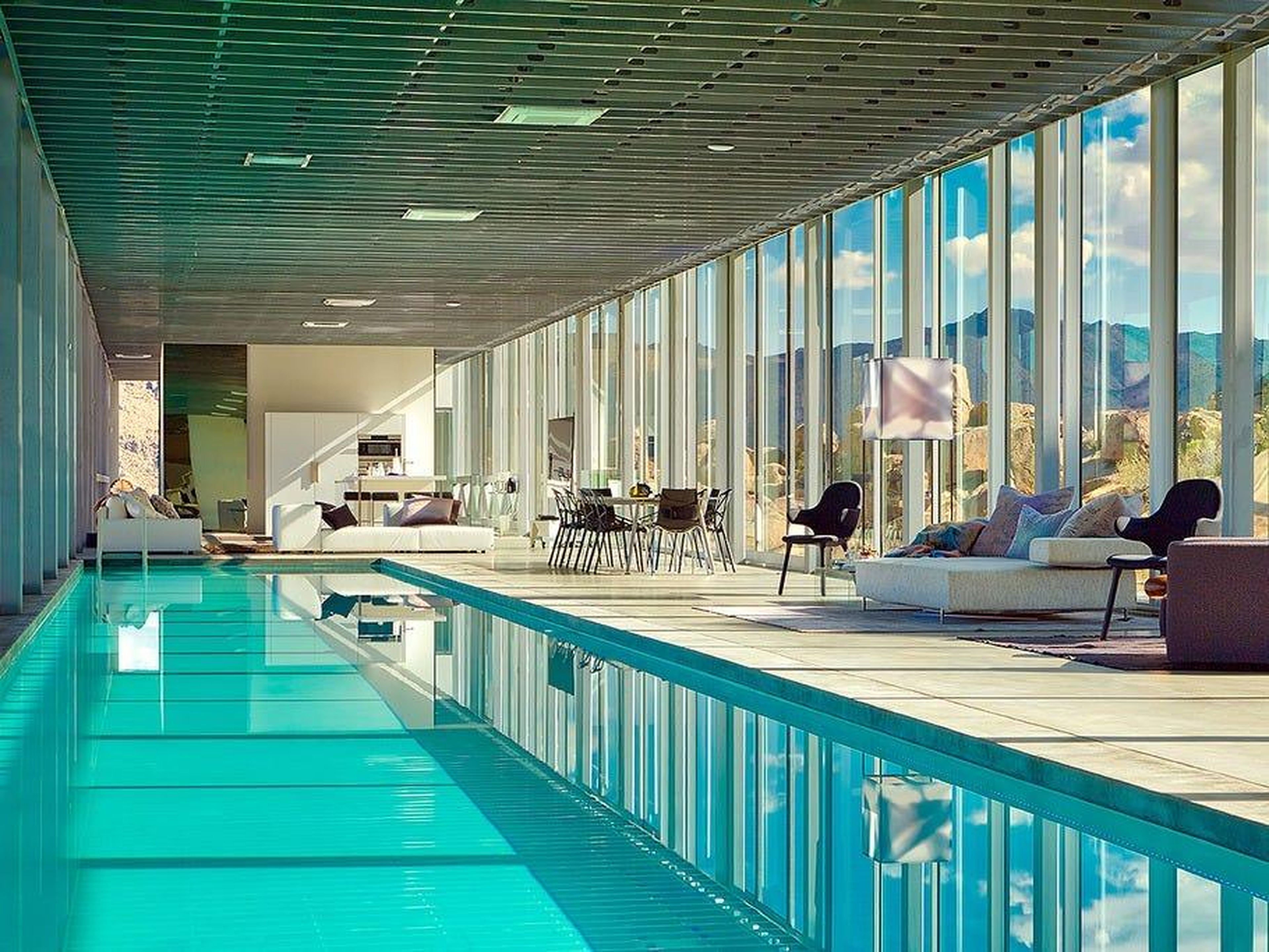 The central living space includes a 100-foot-long pool and mix of seating areas.