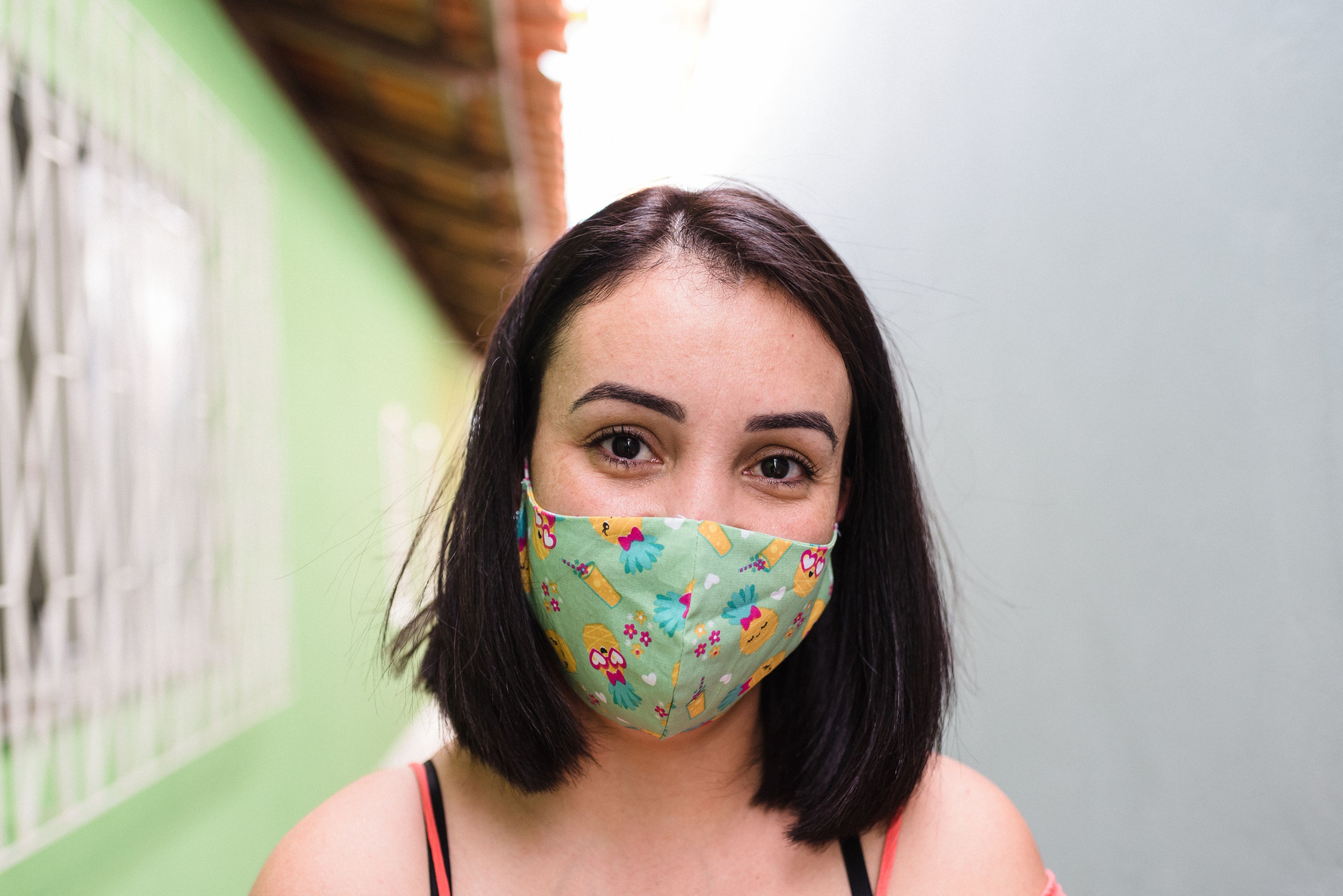 Una chica joven utiliza una mascarilla de tela para protegerse del coronavirus