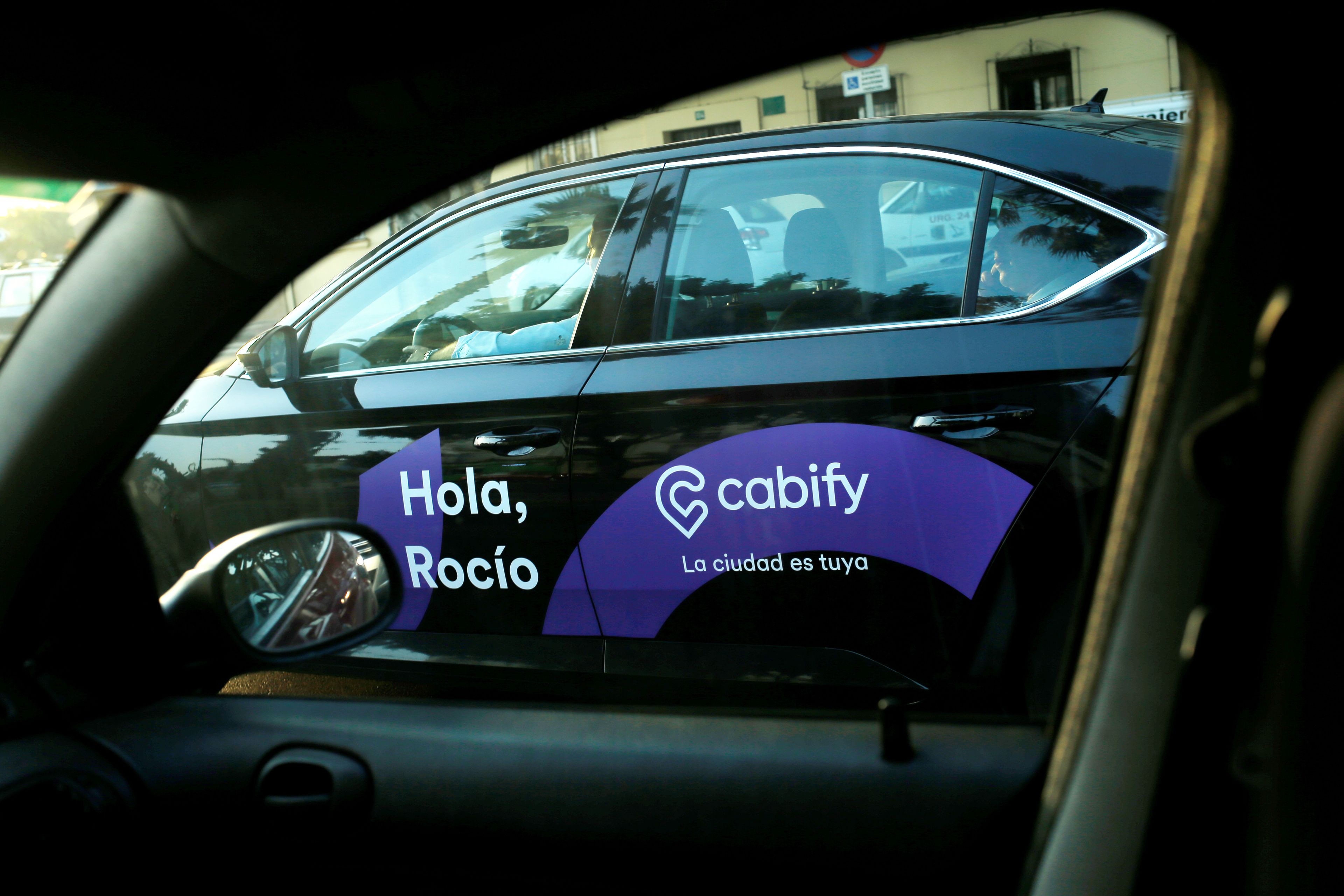 Un coche de Cabify, a través de la ventana de otro vehículo, en Málaga.