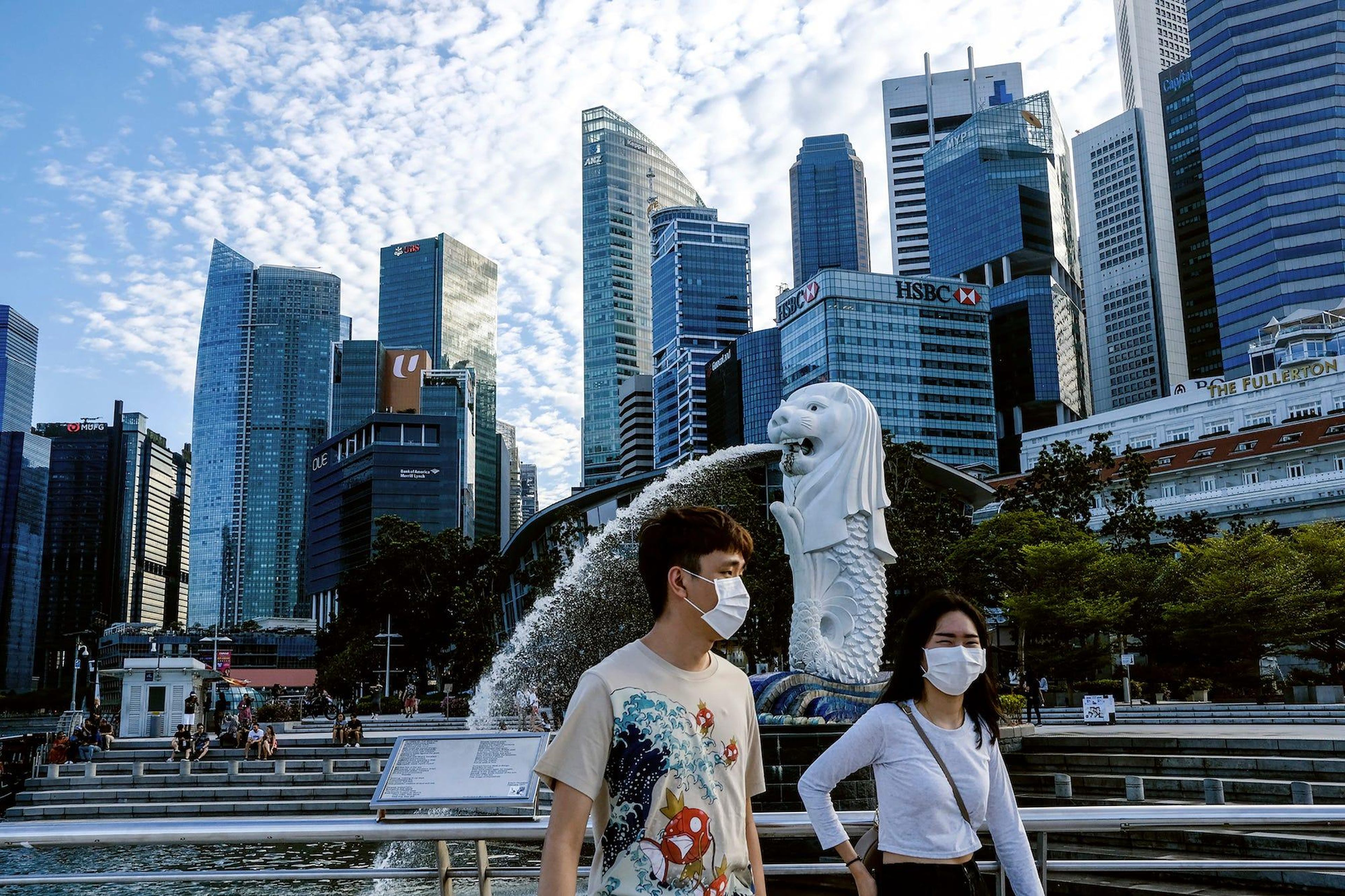 Una pareja con mascarillas camina por Singapur durante el brote de coronavirus del 14 de marzo de 2020.
